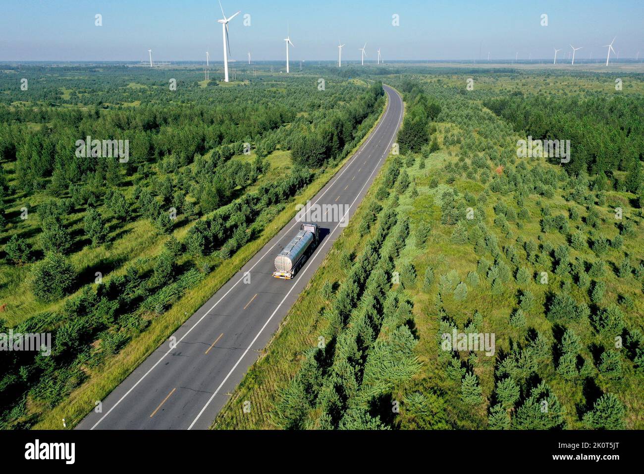 Hohhot. 16th ago, 2022. La foto aerea scattata il 16 agosto 2022 mostra un camion che corre su una strada circondata da foreste nella bandiera posteriore dell'ala sinistra di Horqin della città di Tongliao nella regione autonoma della Mongolia interna della Cina settentrionale. Credit: Notizie dal vivo su Hua Weiguang/Xinhua/Alamy Foto Stock