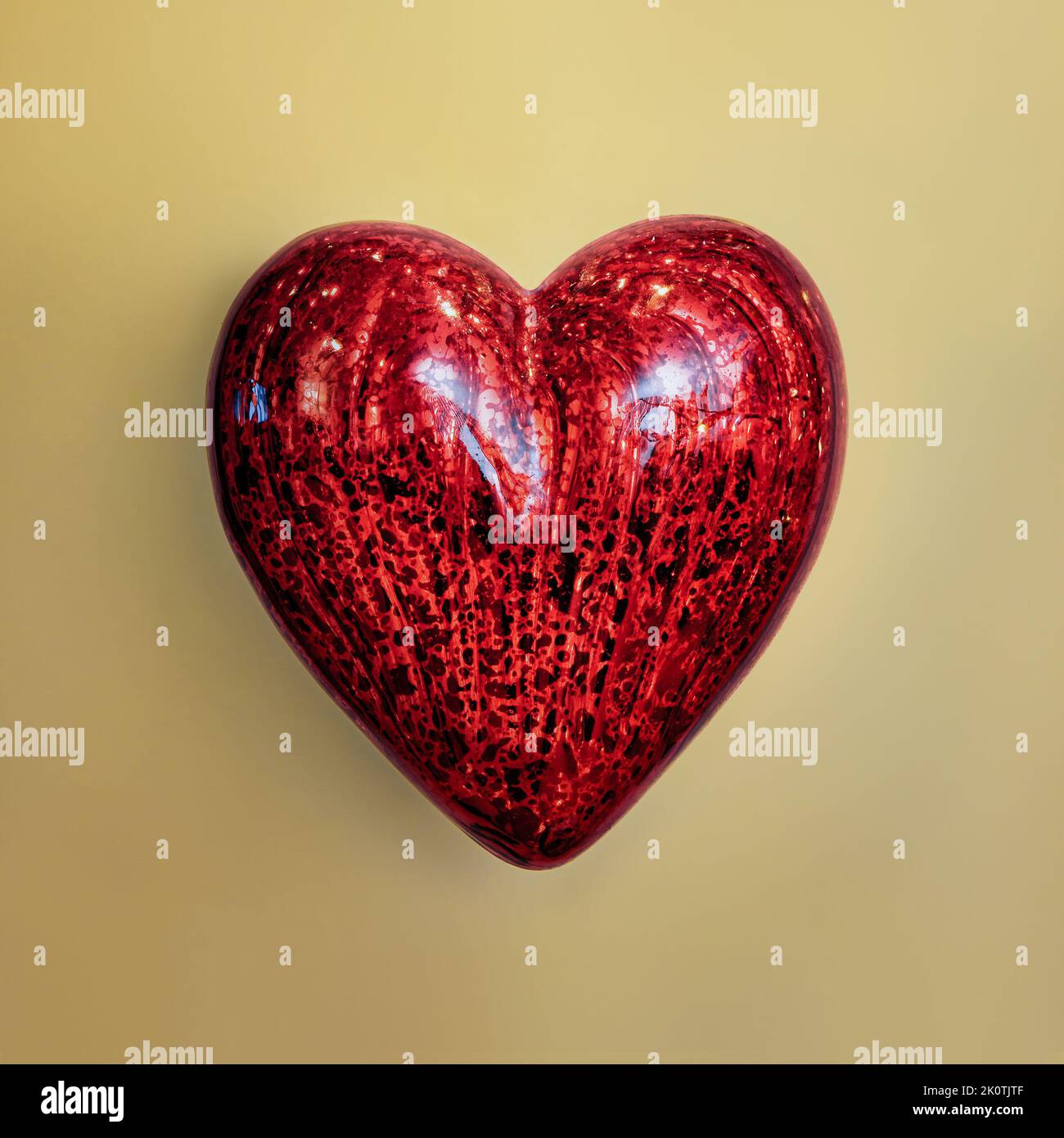 Adorabile ornamento a cuore rosso su sfondo giallo Foto Stock