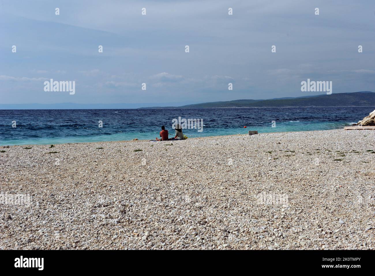 Coppia guardando il turchese, blu oceano di Vaska Boda, Croazia. Persone non riconoscibili sulla spiaggia. Foto Stock