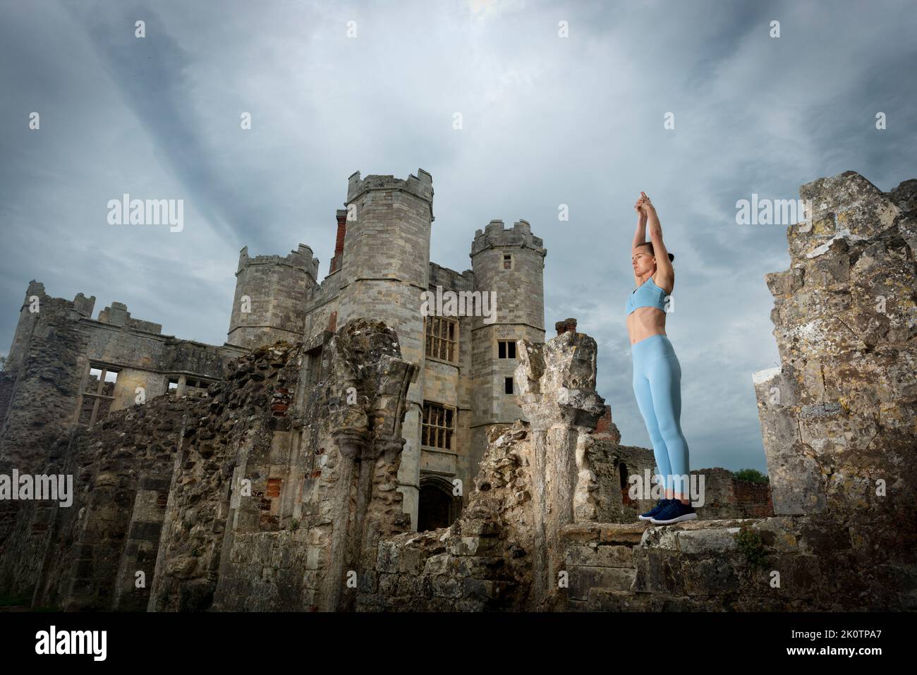 Donna sportiva e in forma che pratica yoga e medita in piedi in rovine storiche Foto Stock