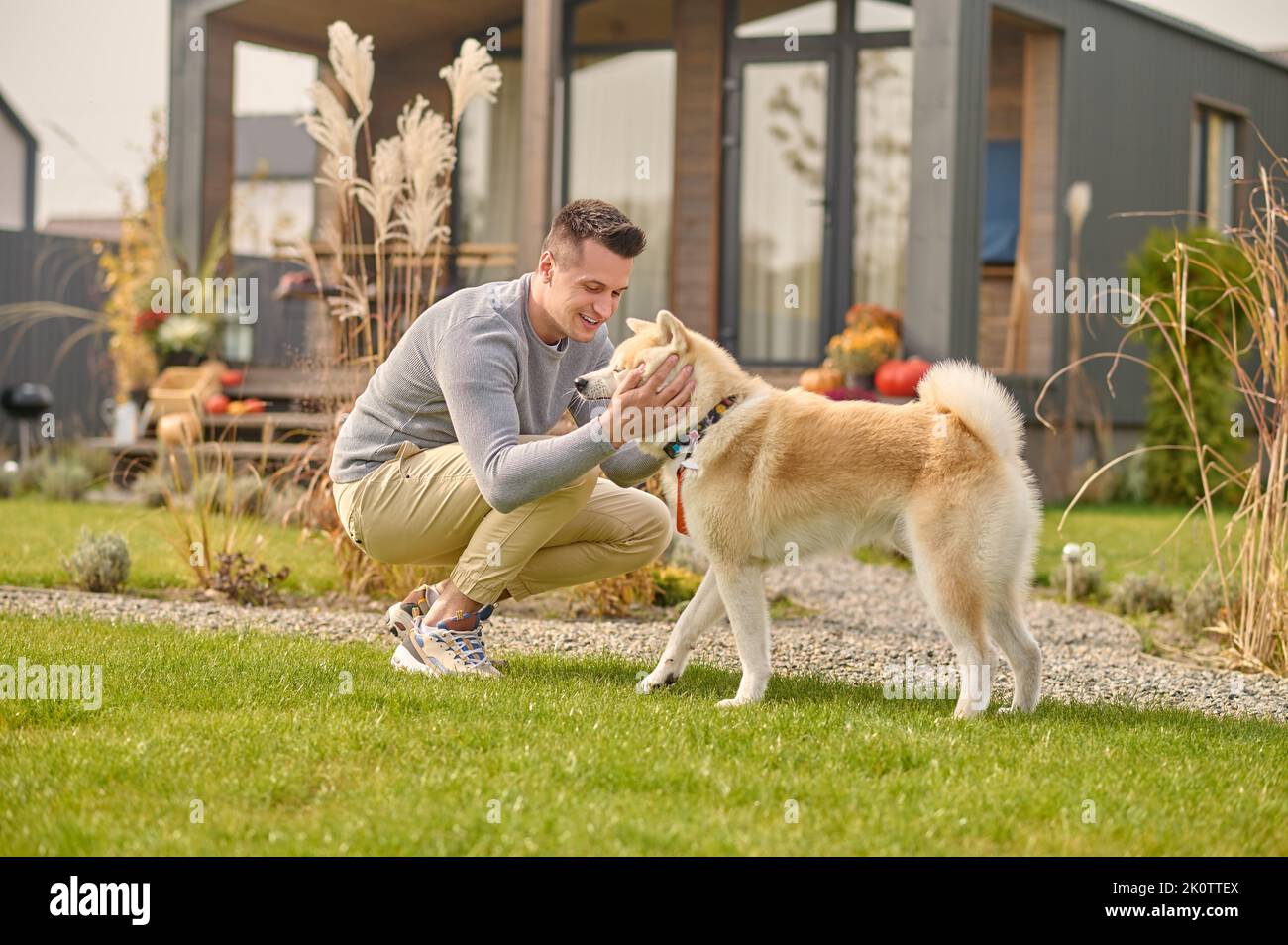 Compiaceva l'uomo e il suo adorabile cane nel cortile Foto Stock