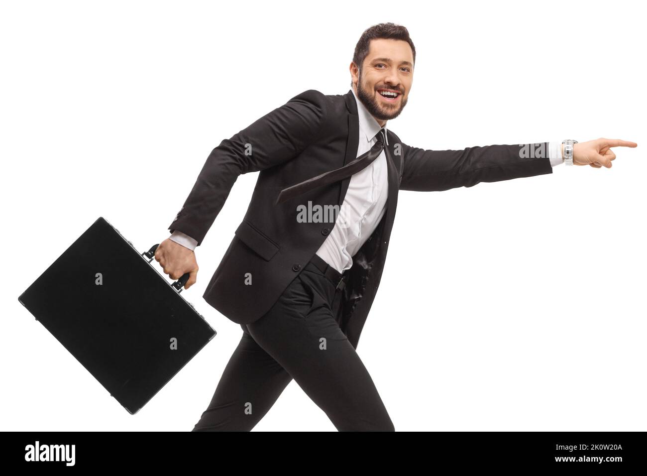 Uomo d'affari in una tuta nera che corre con una valigetta e punta in avanti isolato su sfondo bianco Foto Stock