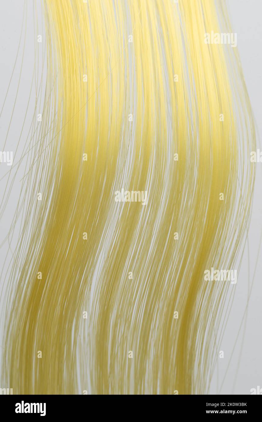 Ciocche di capelli ricci gialli vista ravvicinata isolata Foto Stock