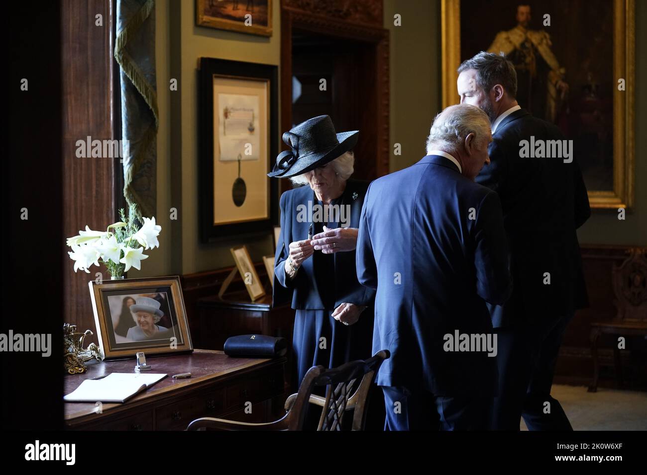 Re Carlo III e la Regina Consort hanno problemi con una penna, mentre firmano il libro dei visitatori a Hillsborough Castle, Co Down. Data immagine: Martedì 13 settembre 2022. Foto Stock
