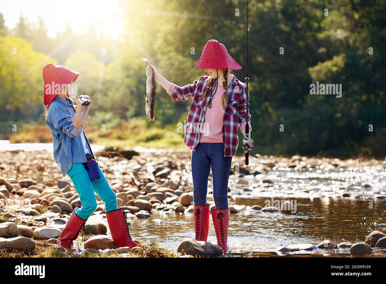 Guarda quello che ho catturato. Due ragazze che pescano da un fiume. Foto Stock