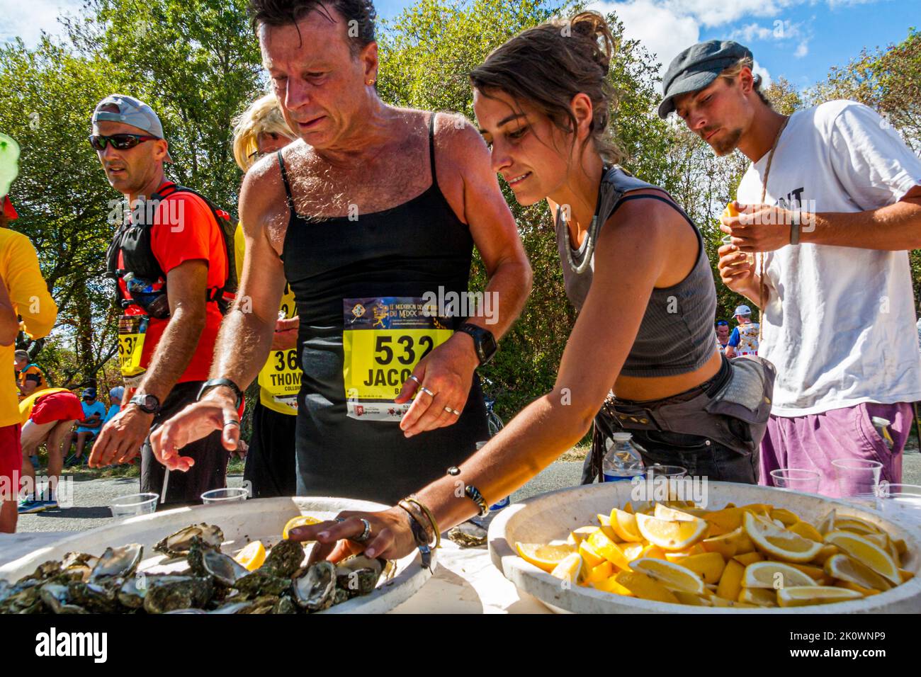 La maratona del 36th dei Chateaux du Medoc era molto affollata allo stand delle ostriche. La specialità culinaria è stata preparata per i corridori in modo che l'ostrica possa essere slurpata direttamente dal guscio, in stile con qualche goccia di limone e vino bianco. Lesparre-Médoc, Francia Foto Stock