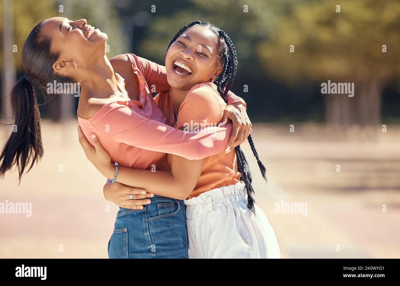 Amici o donne felici abbracciano e ridono insieme nella natura in un parco o in una foresta. Sorrido, allegre sorelle abbraccianti, che si legano, che si godono una giornata all'aperto e. Foto Stock