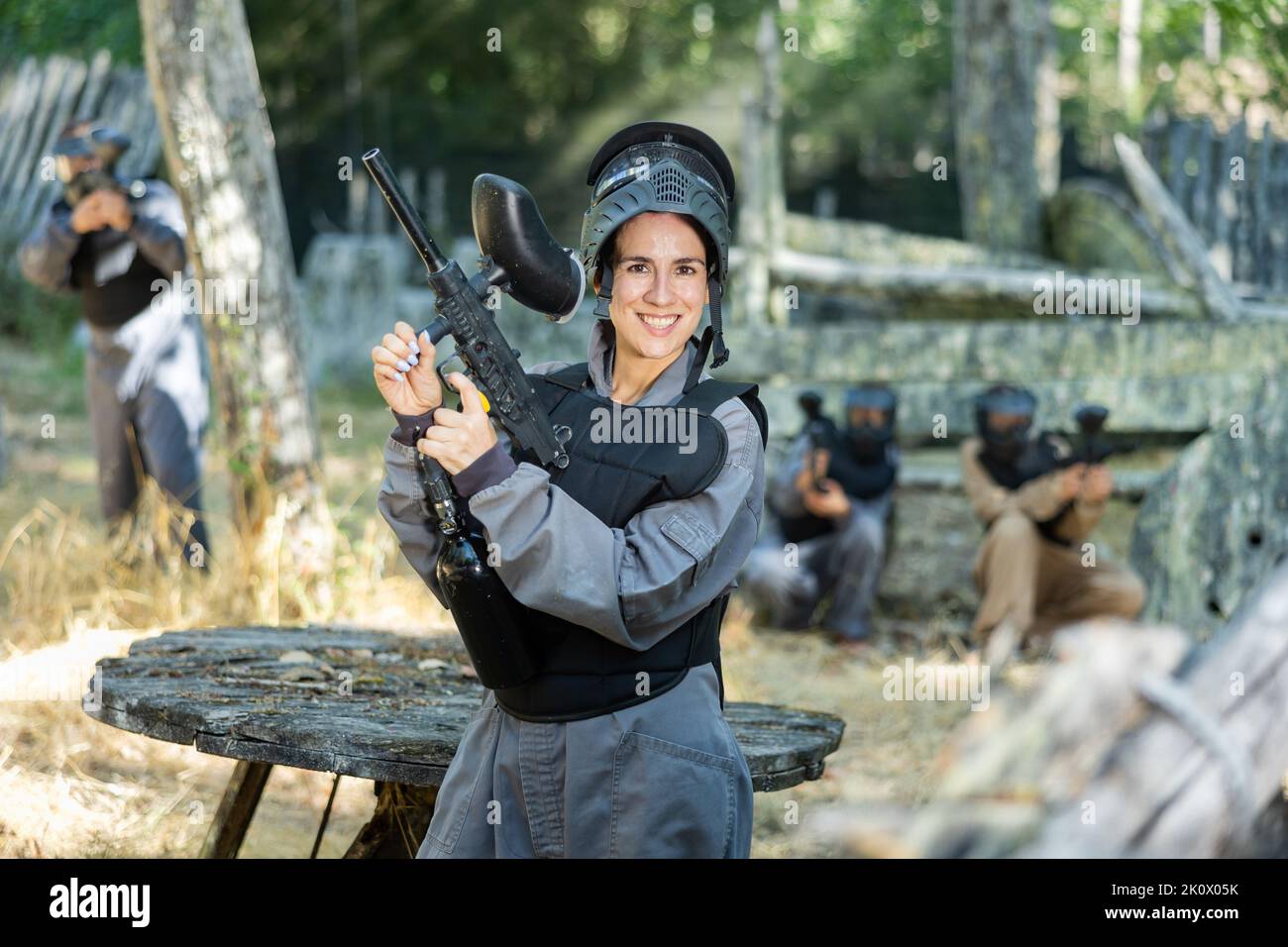 Ritratto di donna sorridente in uniforme con pistola paintball Foto Stock