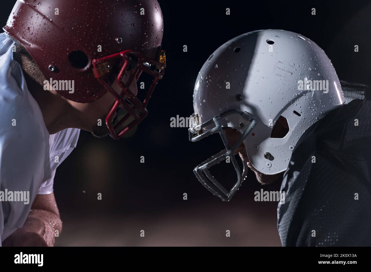 Due american football giocatori faccia a faccia in silhouette ombra su sfondo bianco Foto Stock