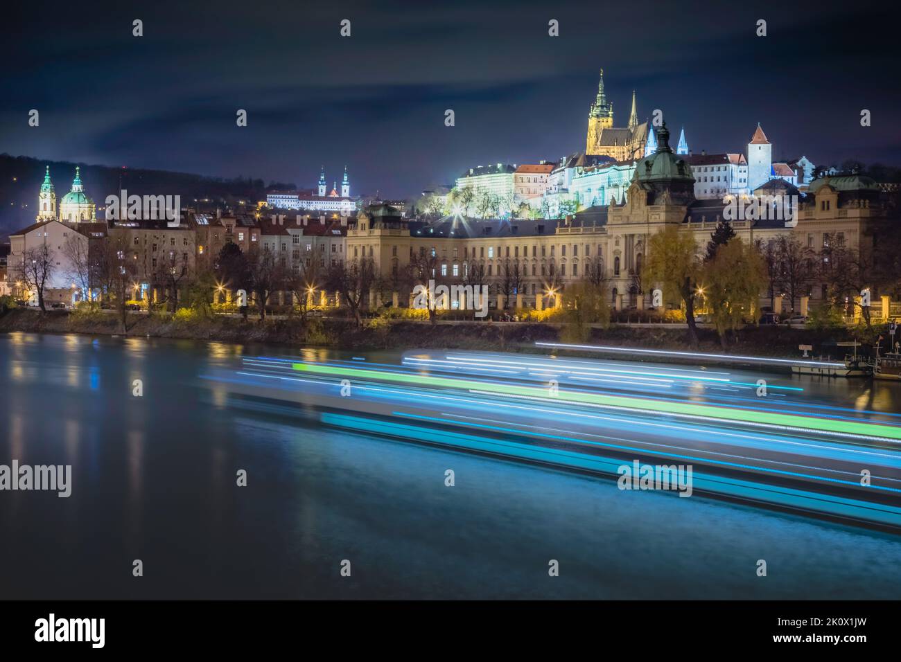 Hradcany, Cattedrale di San Vito e fiume Moldava di notte con barca sfocata, Praga Foto Stock