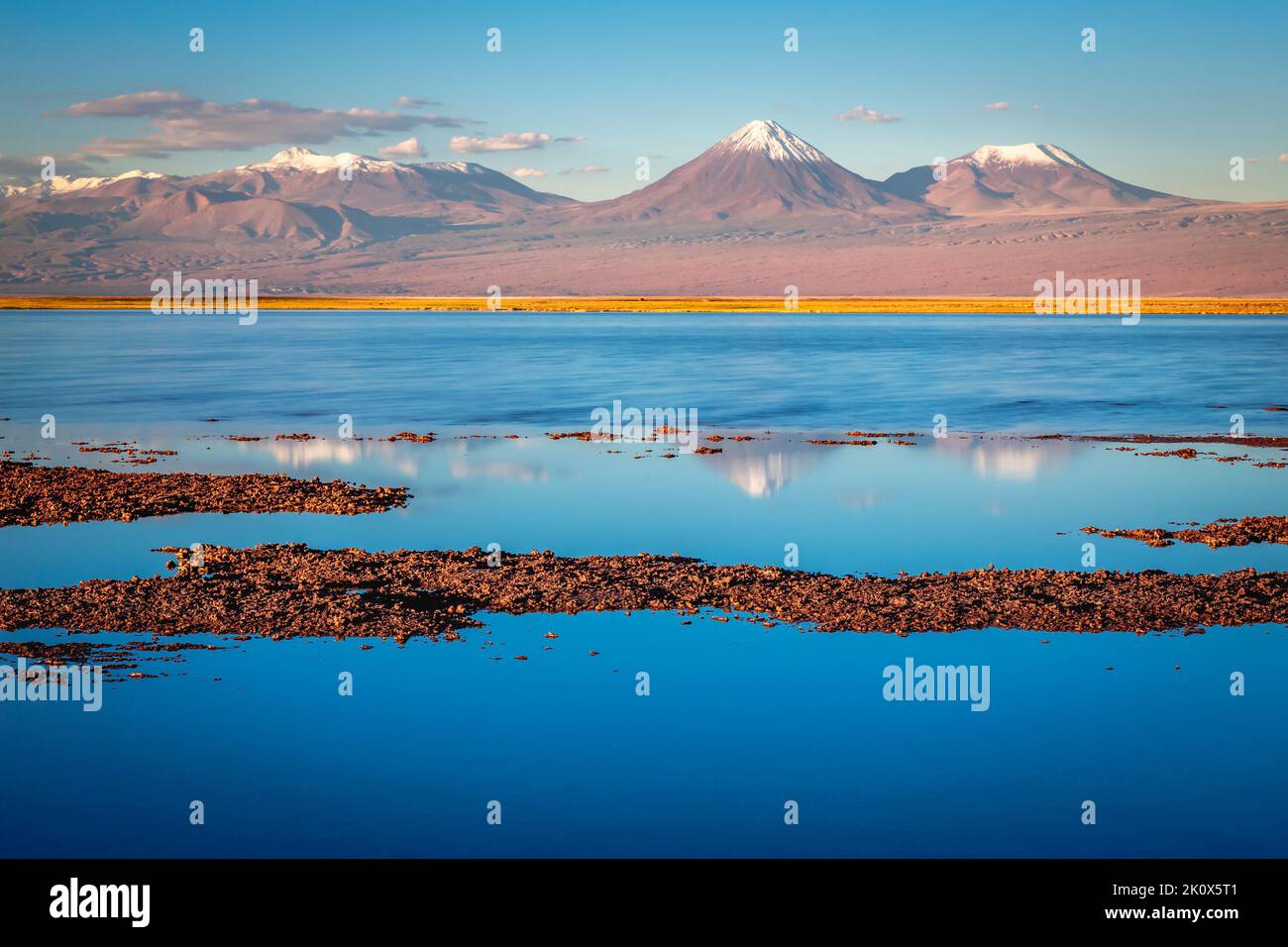 Paesaggio vulcanico e lago di sale riflessione al tramonto nel deserto di Atacama, Cile Foto Stock