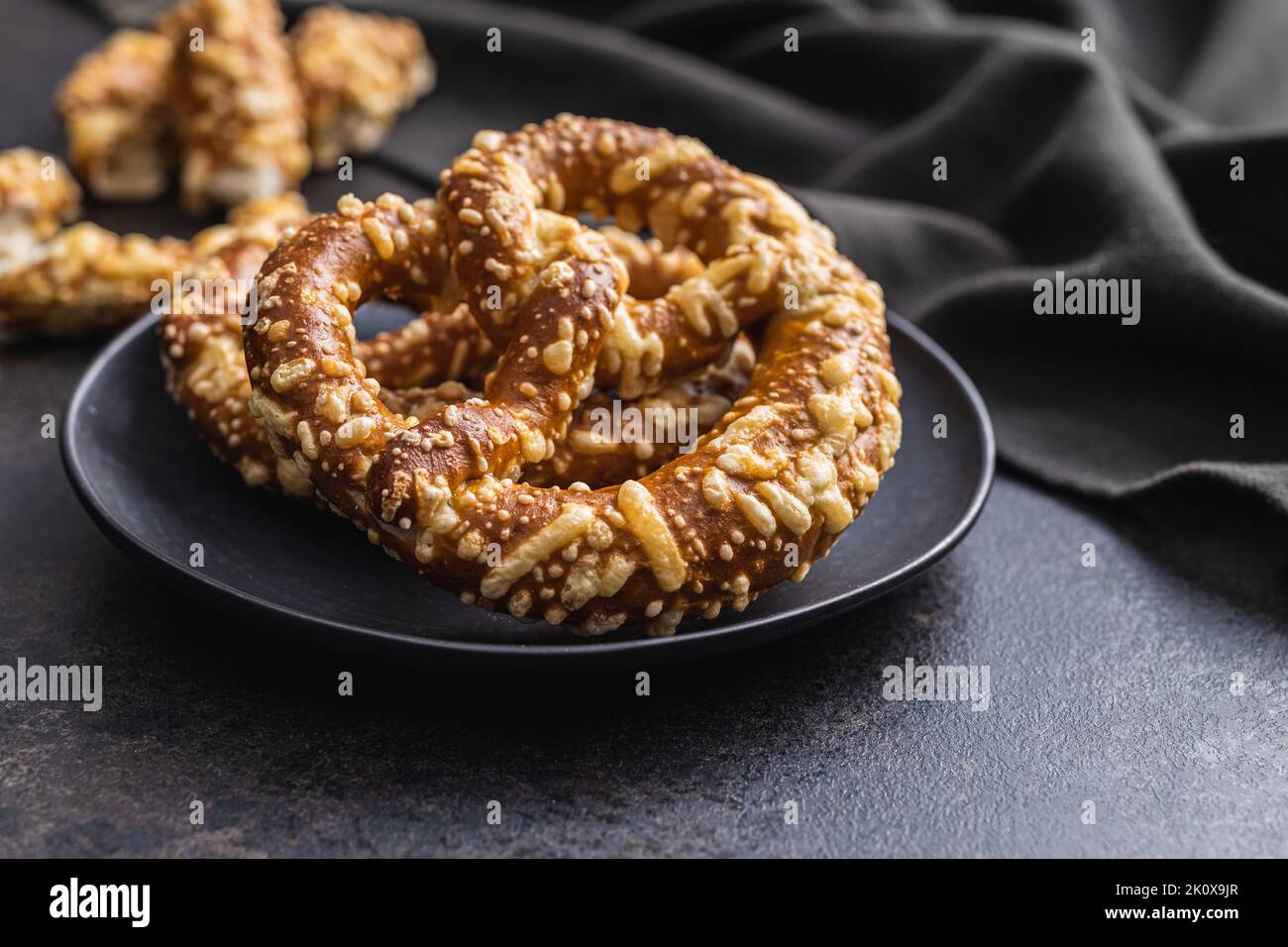 Pretzel di pane tedesco con formaggio al forno sul tavolo da cucina. Foto Stock