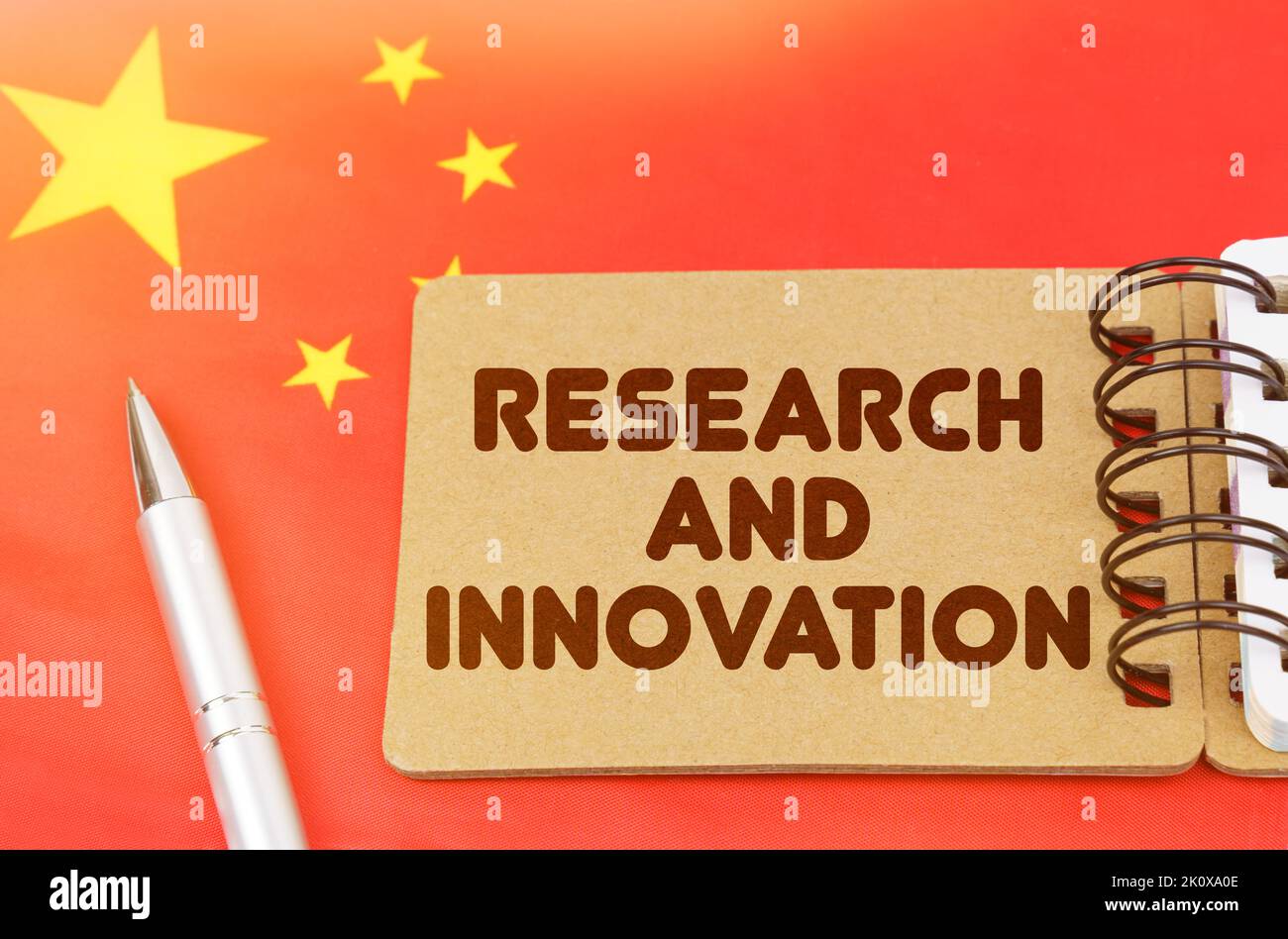 Concetto di economia nazionale. Sulla bandiera della Cina si trova un notebook con l'iscrizione - Ricerca e innovazione Foto Stock
