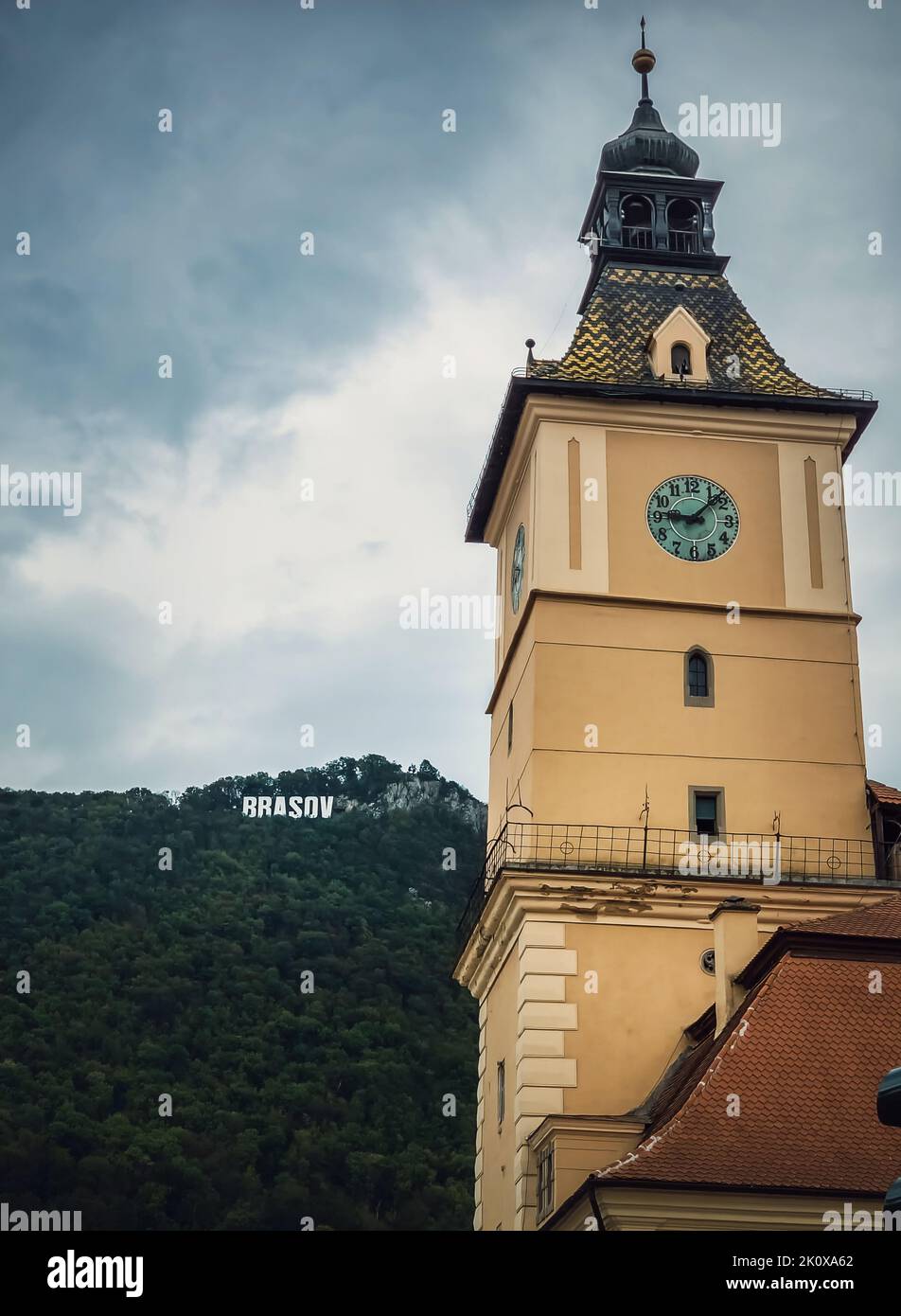 La torre dell'orologio della casa del consiglio con una splendida vista sul cartello di Brasov in cima alla collina. Posizione turistica popolare in Romania Foto Stock