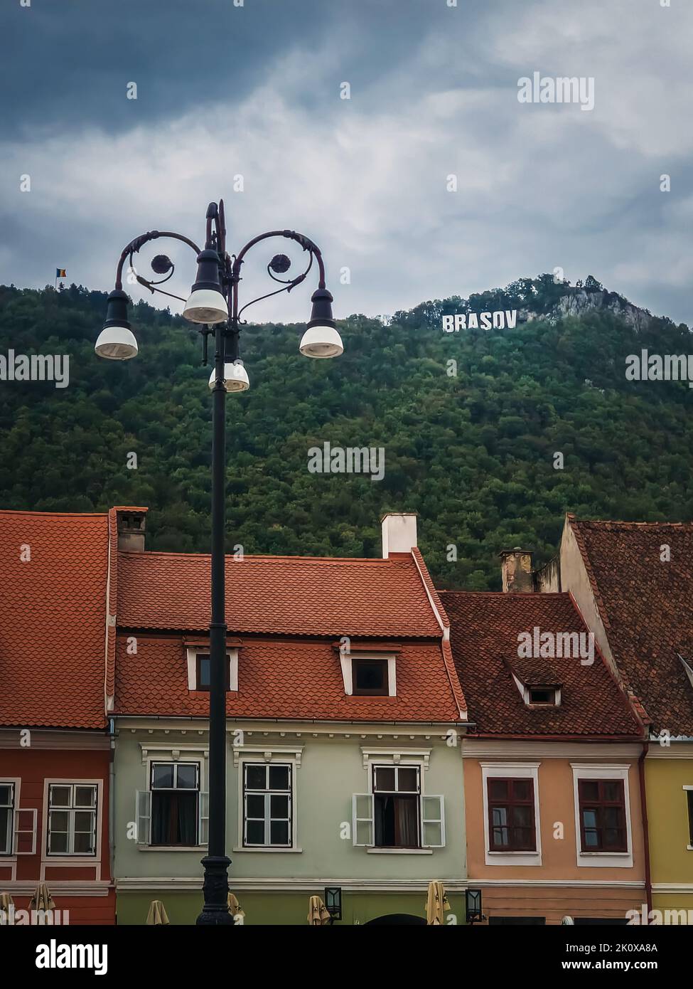 La città vecchia di Brasov con colorati edifici vintage in stile tradizionale sassone con vista sul cartello in cima alla collina. Popolare località turistica Foto Stock