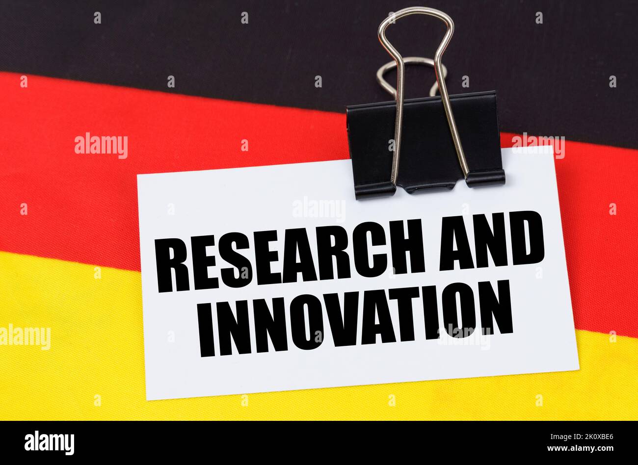 Concetto di economia nazionale. Sulla bandiera della Germania si trova un notebook con l'iscrizione - Ricerca e innovazione Foto Stock