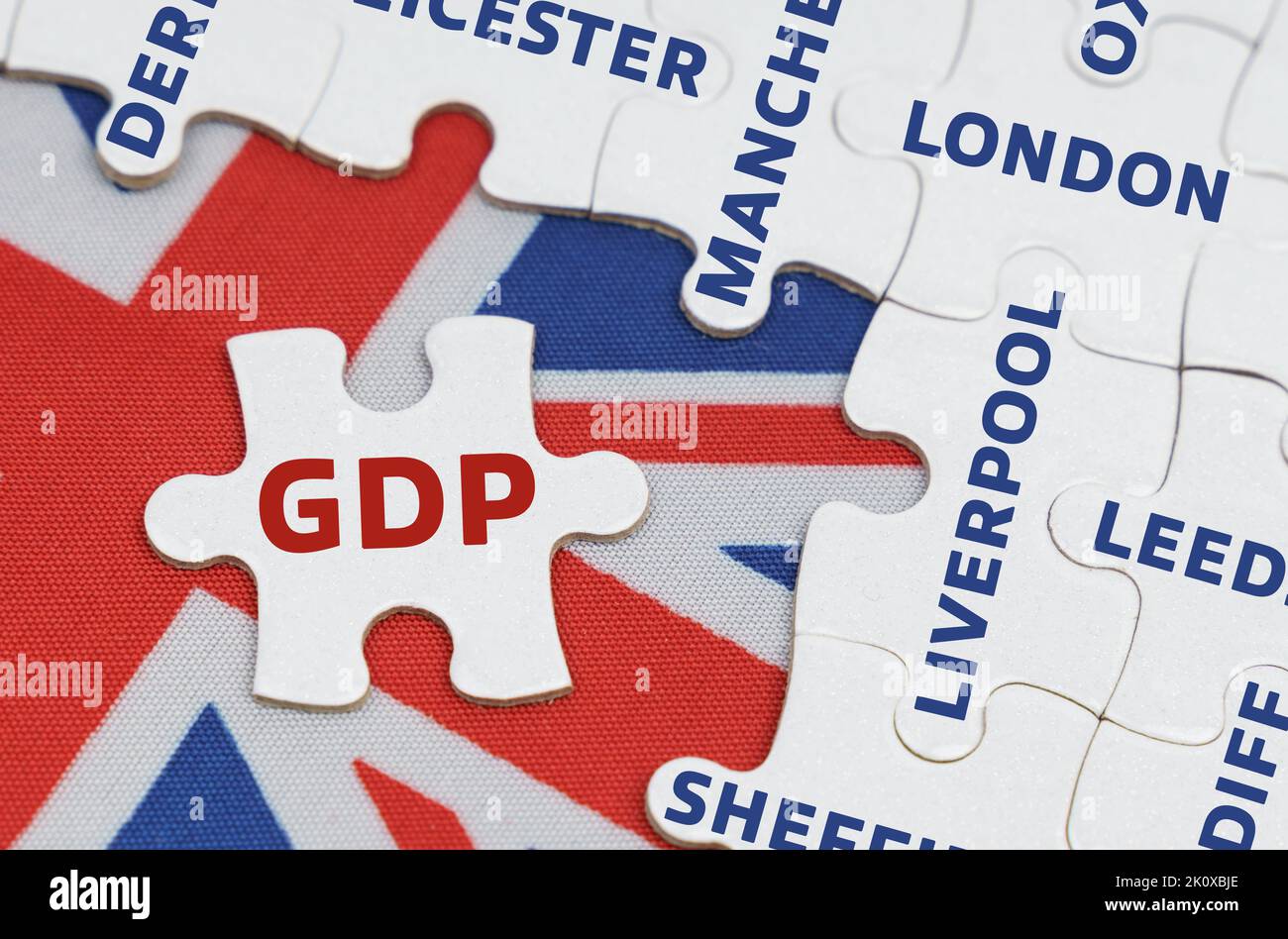 Concetto nazionale. Sulla bandiera della Gran Bretagna ci sono puzzle con i nomi delle città e un puzzle separato con l'iscrizione - Foto Stock