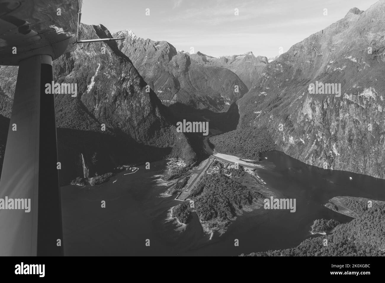 Nuova Zelanda. Milford Sound (Piopiotahi) dall'alto - la testa del fiordo con il molo e l'Aeroporto di Milford Sound. Foto Stock
