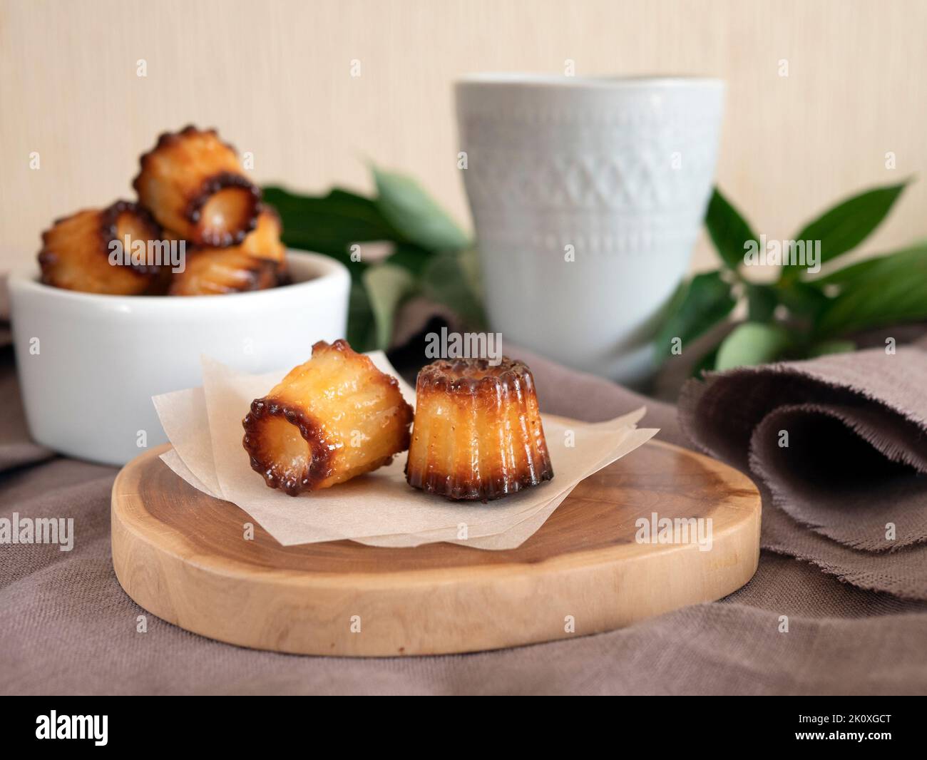Mini Canele francesi per tè o caffè, focalizzazione selettiva. Dolci Caneles de Bordeaux. Dessert servito splendidamente Foto Stock