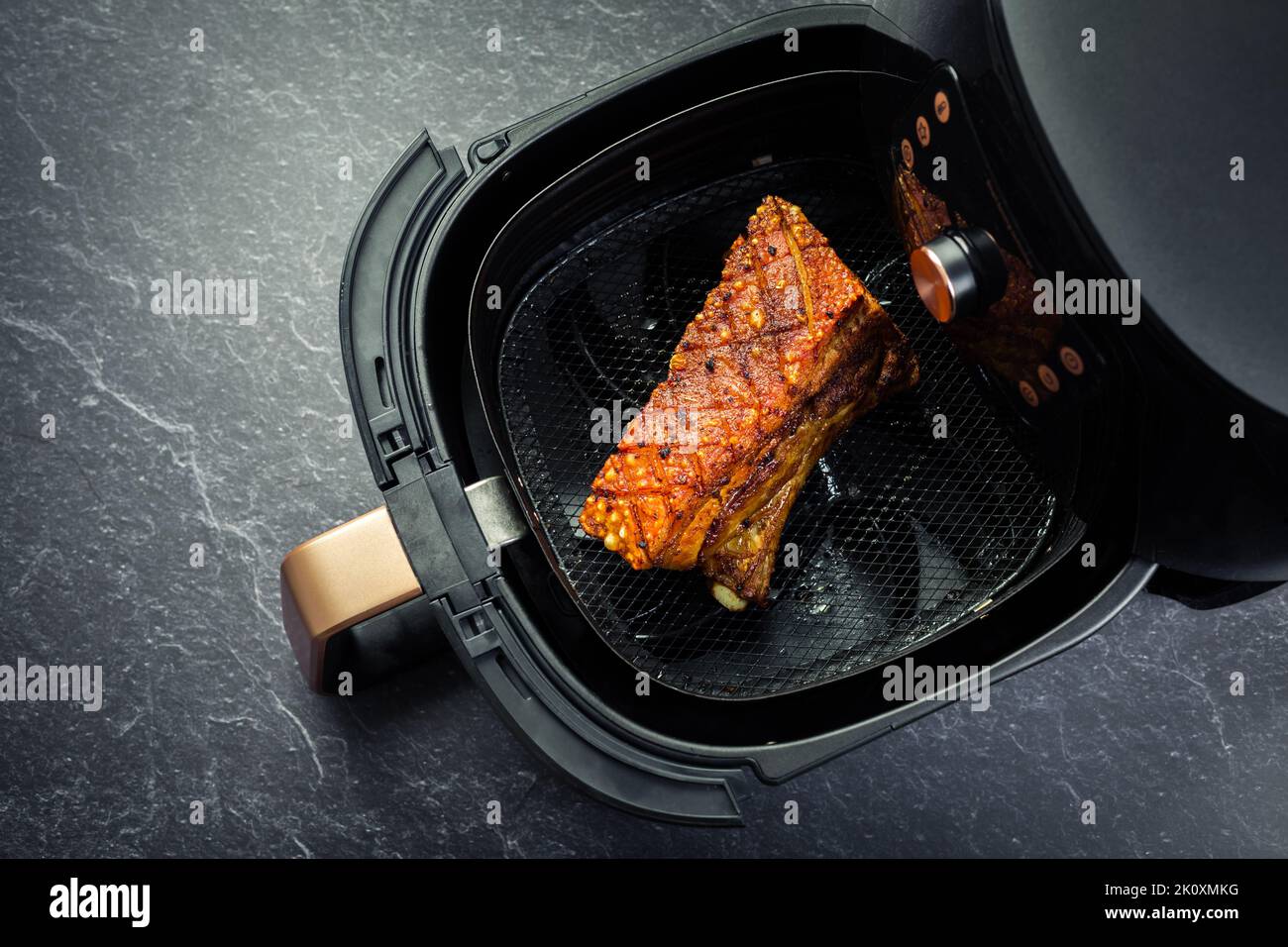 Cuoce croccante di maiale in airfryer. Cottura rapida e semplice di alimenti croccanti con poco o nessun grasso facendo circolare aria calda all'interno del cestello Foto Stock