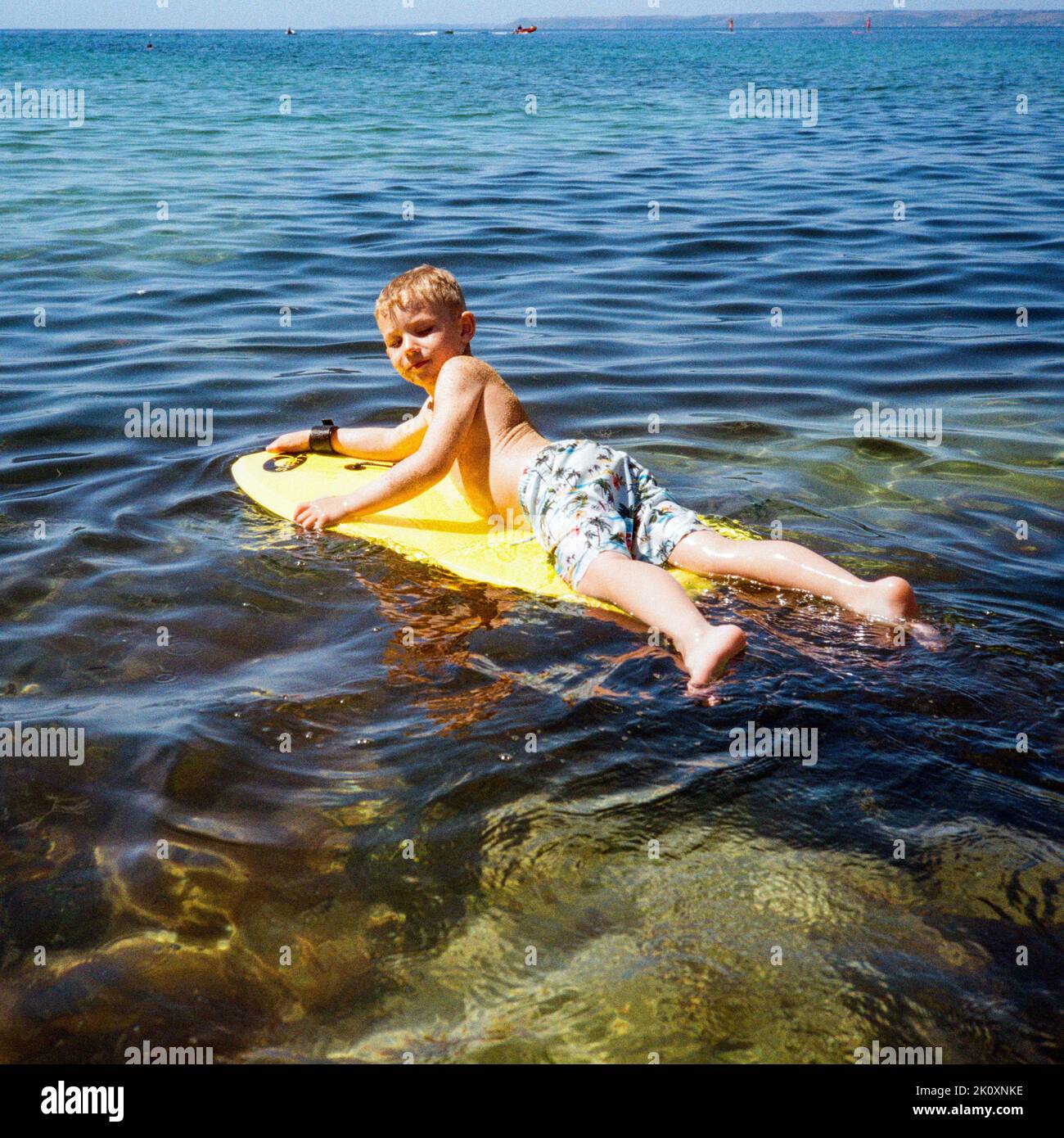 Il bodyboarding del ragazzo di cinque anni, Hope Cove, Devon, Inghilterra, regno unito. Foto Stock