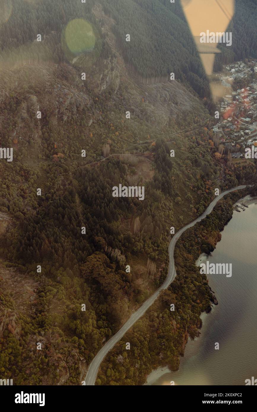 Una strada si snoda intorno al Lago Wakatipu vicino a Queenstown, Nuova Zelanda Foto Stock