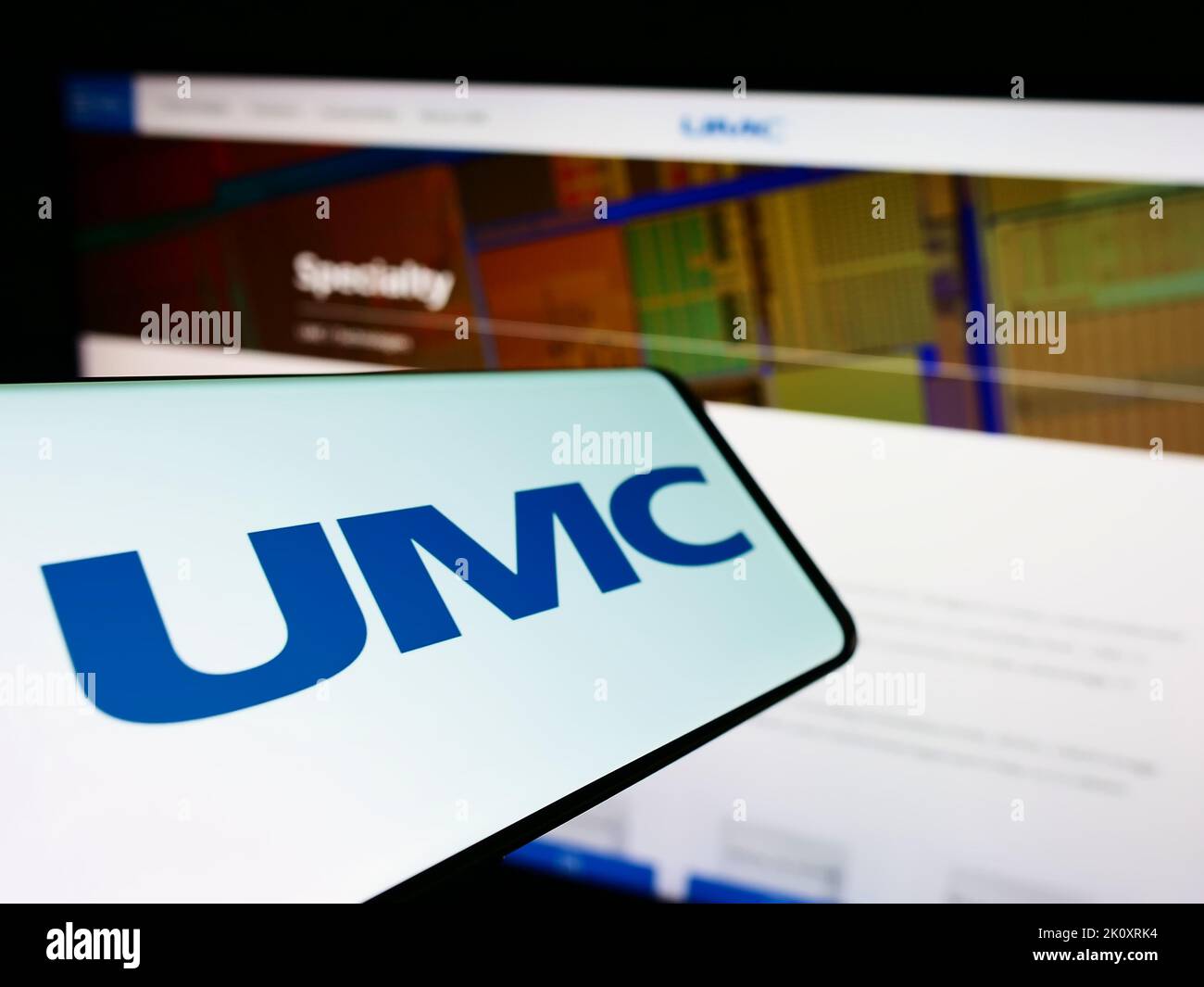 Smartphone con il logo della società United Microelectronics Corporation (UMC) sullo schermo di fronte al sito Web. Messa a fuoco al centro a sinistra del display del telefono. Foto Stock