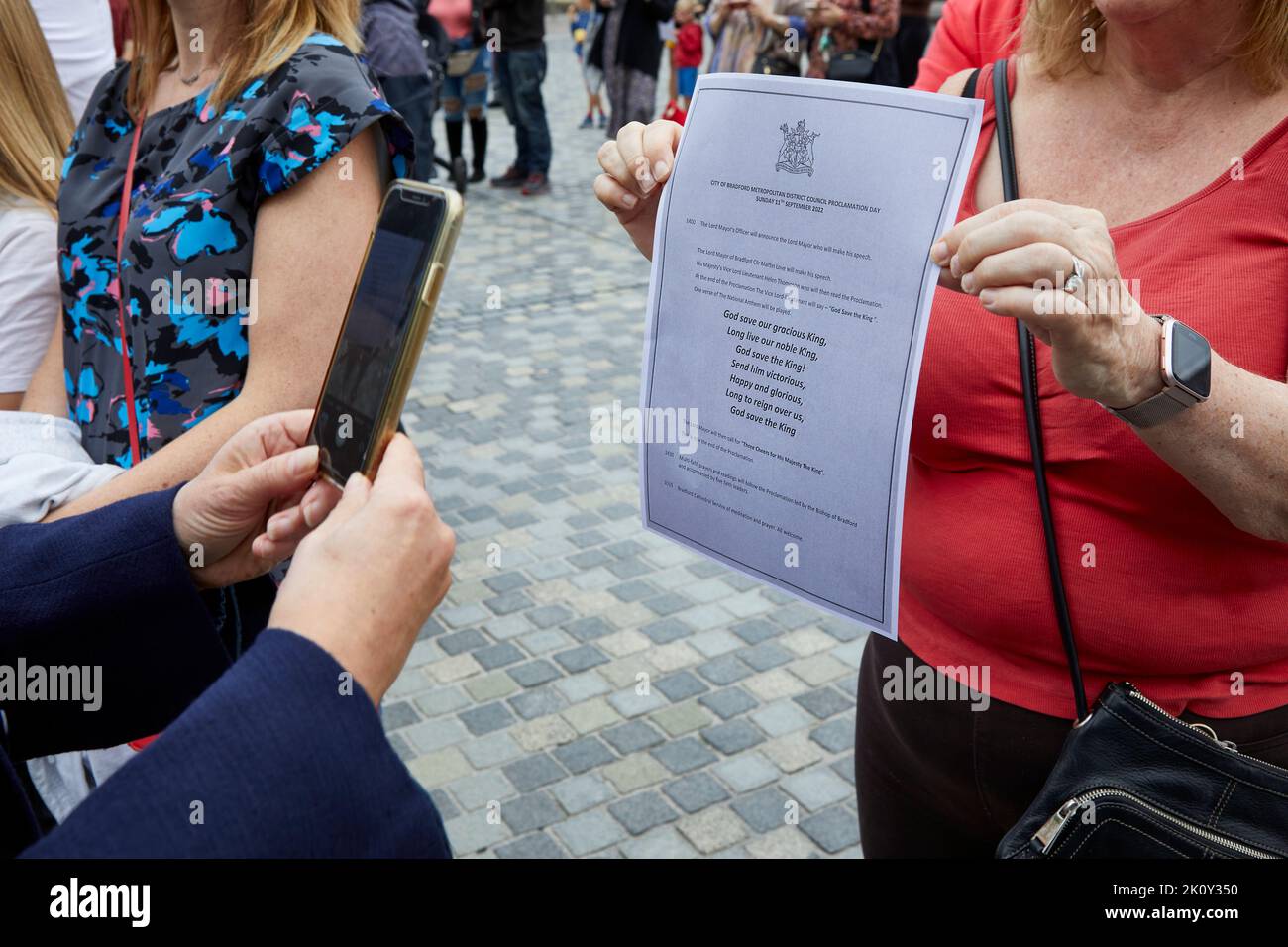 Donna scatta foto con il telefono cellulare di Dio Salva il re Carlo III proclamazione Bradford UK 2022 Foto Stock