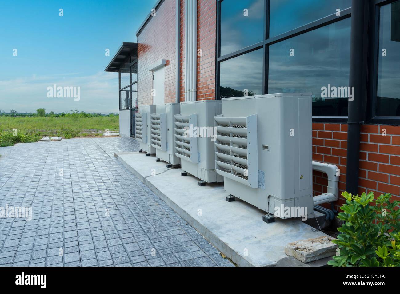 Unità compressore dell'aria o condensatore installata all'esterno dell'edificio. Aria condizionata esterna divisa dell'ufficio Foto Stock