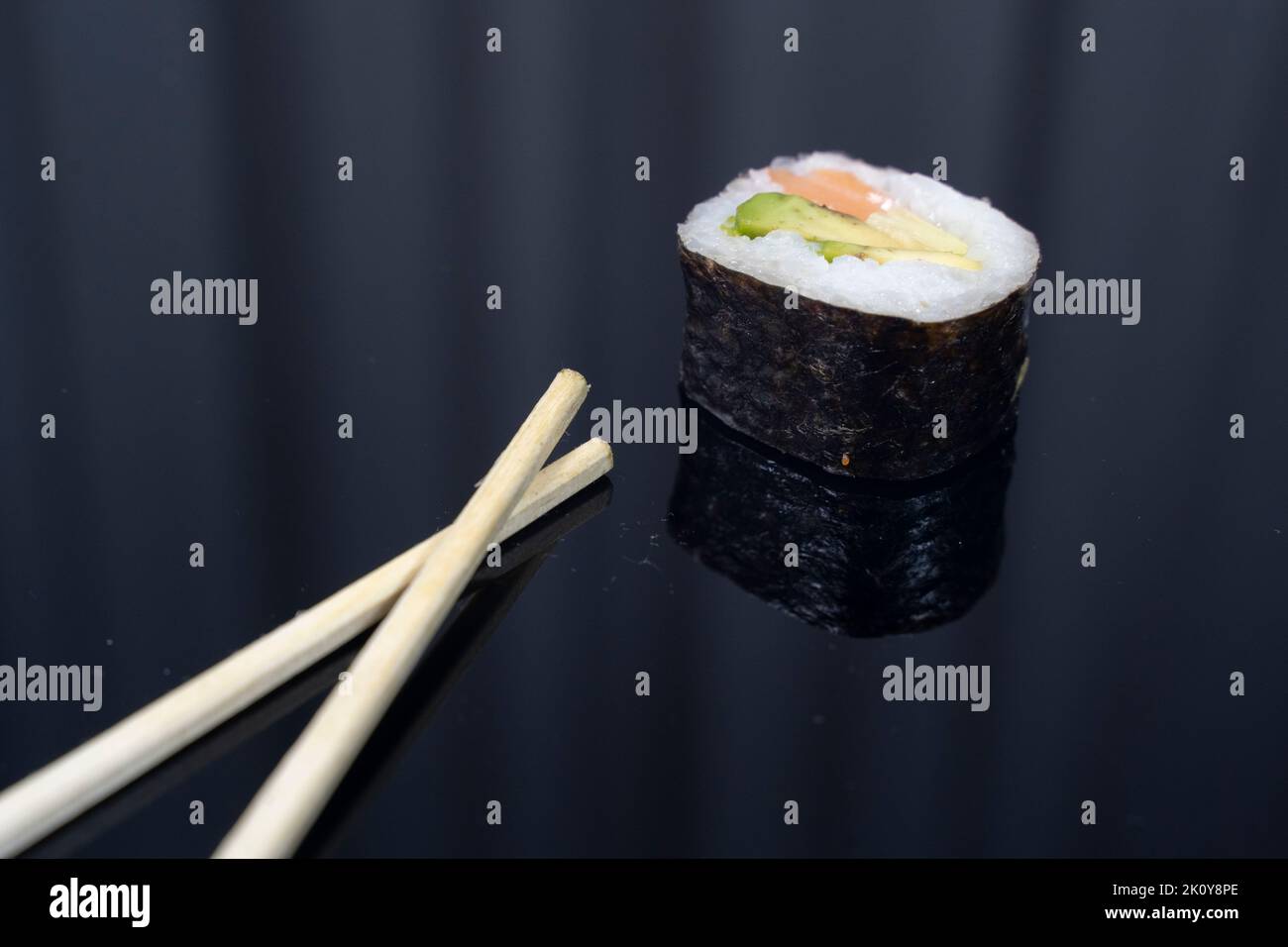 un sushi con bacchette su sfondo scuro Foto Stock
