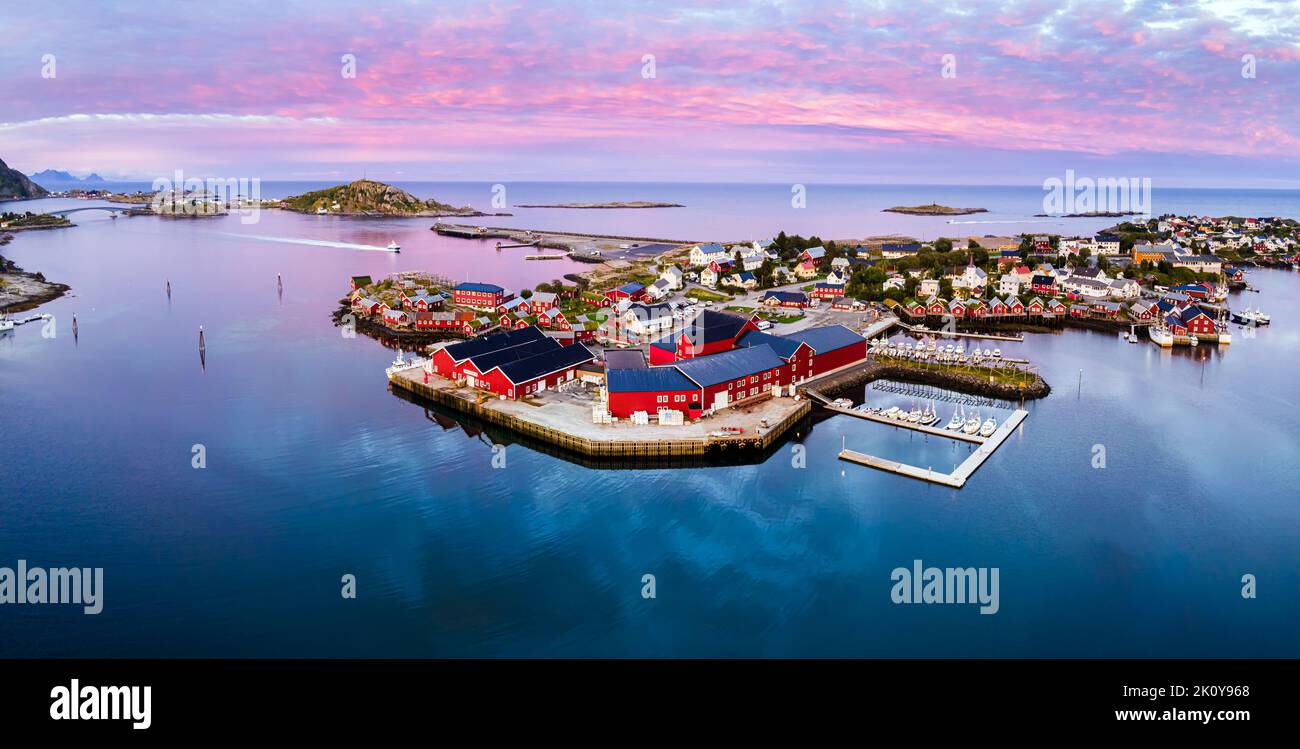 Reine, Lofoten, Norvegia. Tradizionale villaggio di pescatori norvegese con case di legno rosso sulla piccola isola con porto e sole di mezzanotte. Paesaggio nordico, S Foto Stock