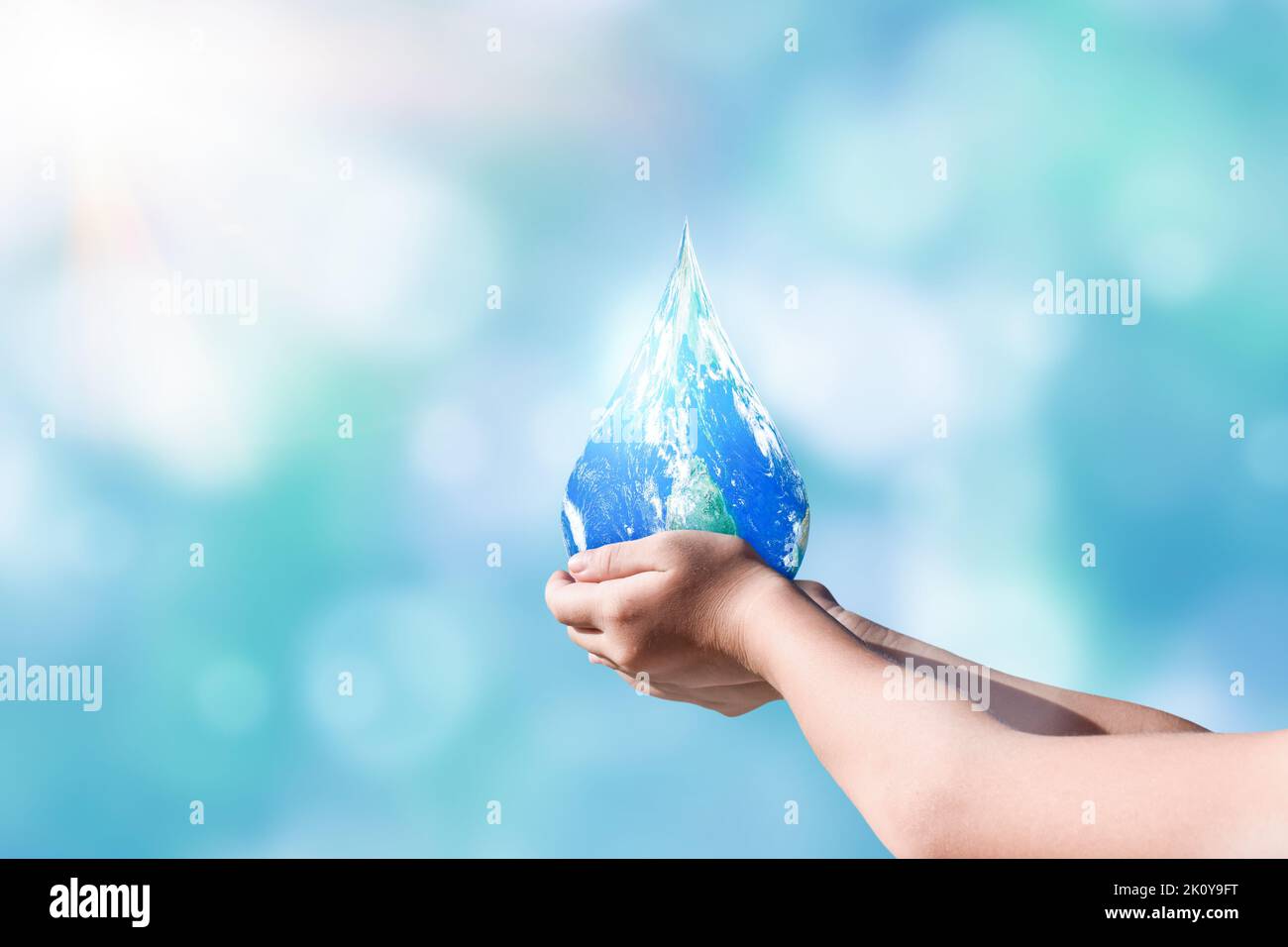 Mani che tengono in forma globale in goccia su sfondo sfocato natura. Giornata mondiale per l'acqua e sostenere per il concetto di terra. Elementi di questa immagine forniti b Foto Stock