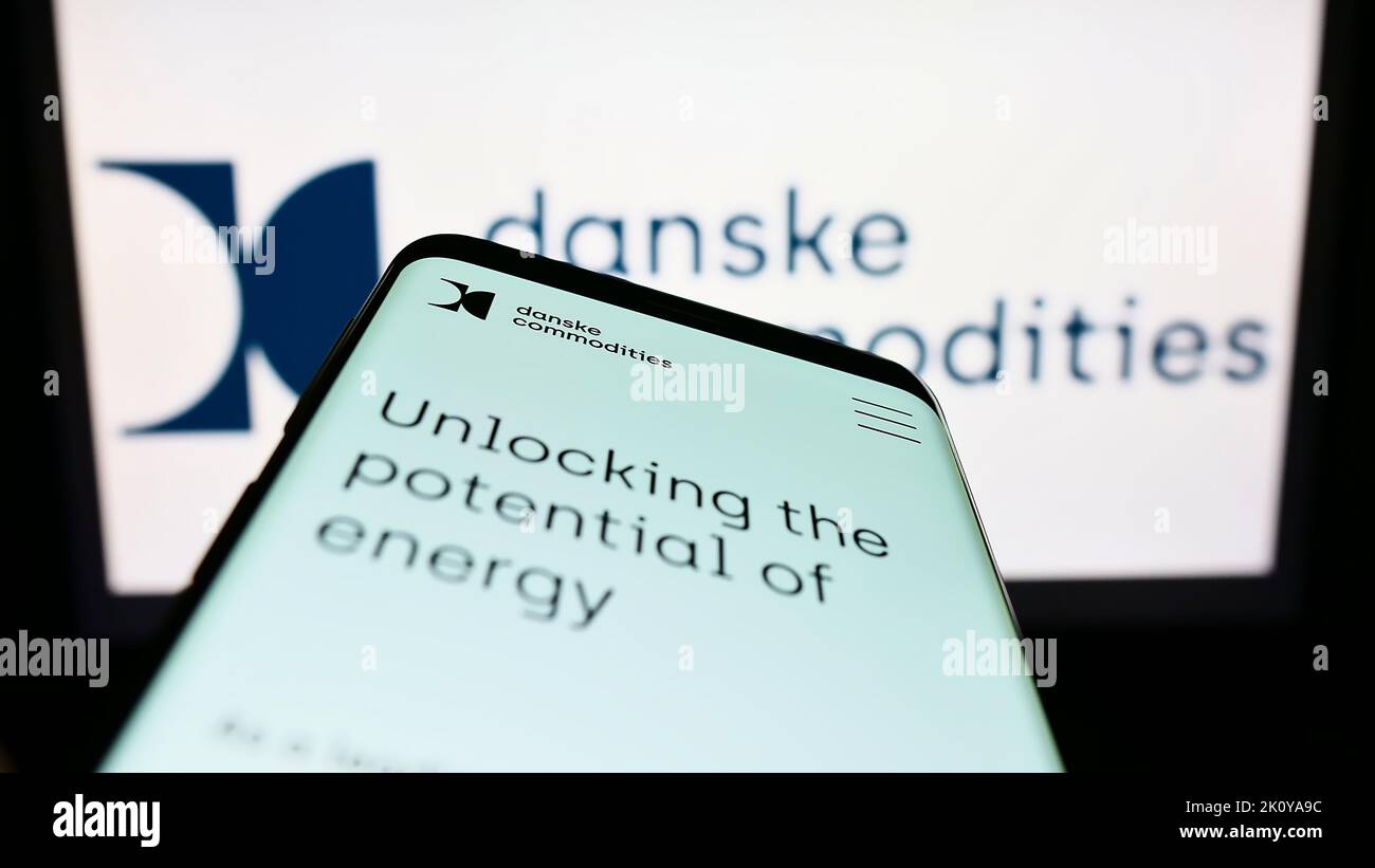 Smartphone con sito web della società di scambio di energia Danske Commodities COME sullo schermo di fronte al logo aziendale. Messa a fuoco in alto a sinistra del display del telefono. Foto Stock