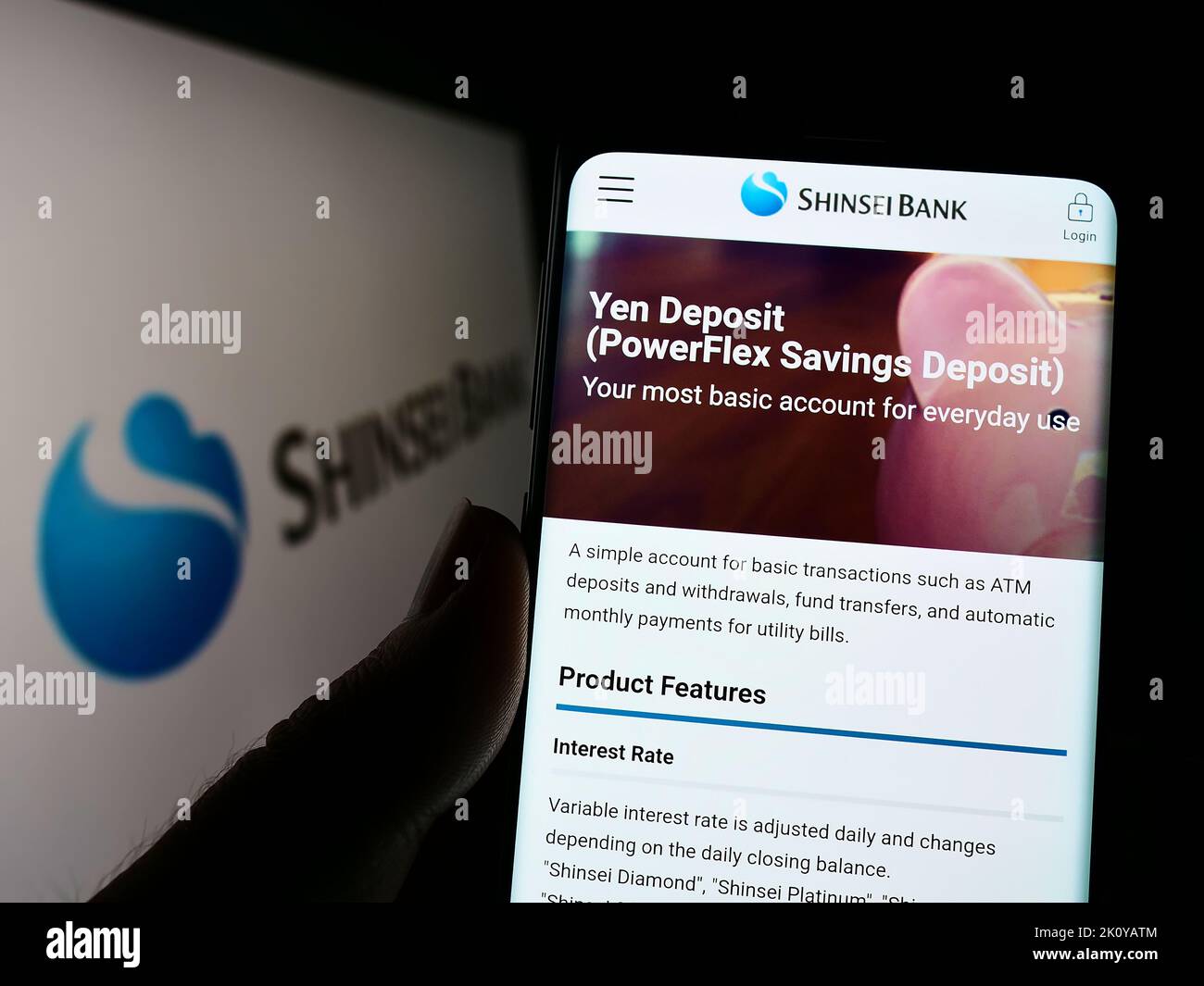 Persona che tiene il cellulare con il sito web della società finanziaria giapponese Shinsei Bank Limited sullo schermo con il logo. Messa a fuoco al centro del display del telefono. Foto Stock