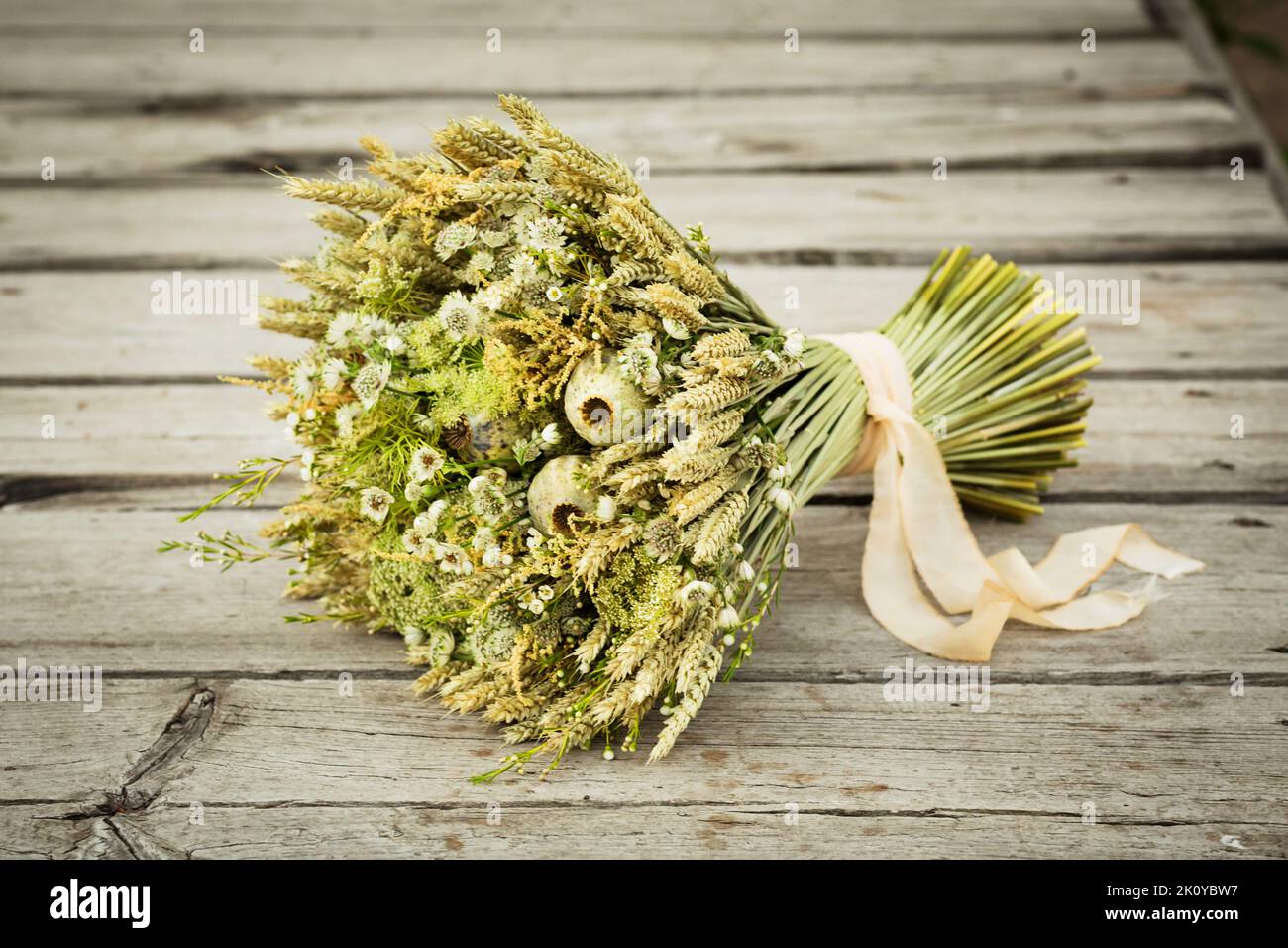 bouquet di fiori secchi. Vita morta con spighe di grano e fiori selvatici gialli e bianchi. Foto Stock