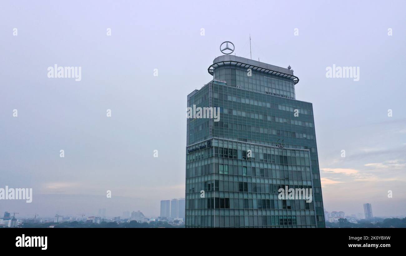 Riflesso del cielo nuvoloso estivo nella facciata di vetro del moderno edificio di uffici nella Città di Giacarta Foto Stock