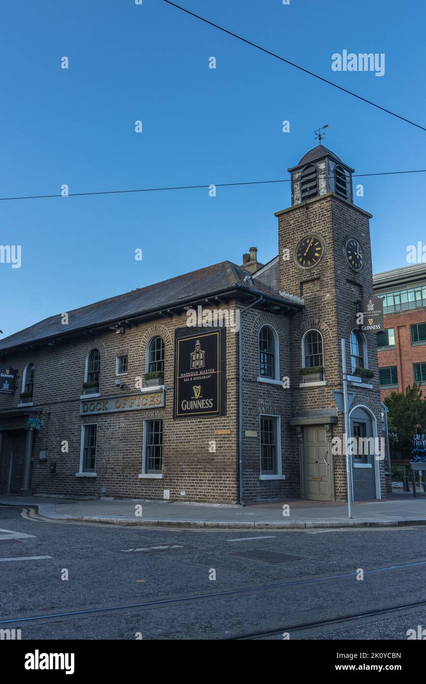 La vista dell'edificio in mattoni grigi del bar e ristorante Harbour Master con una torre dell'orologio a Dublino, Irlanda. Foto Stock