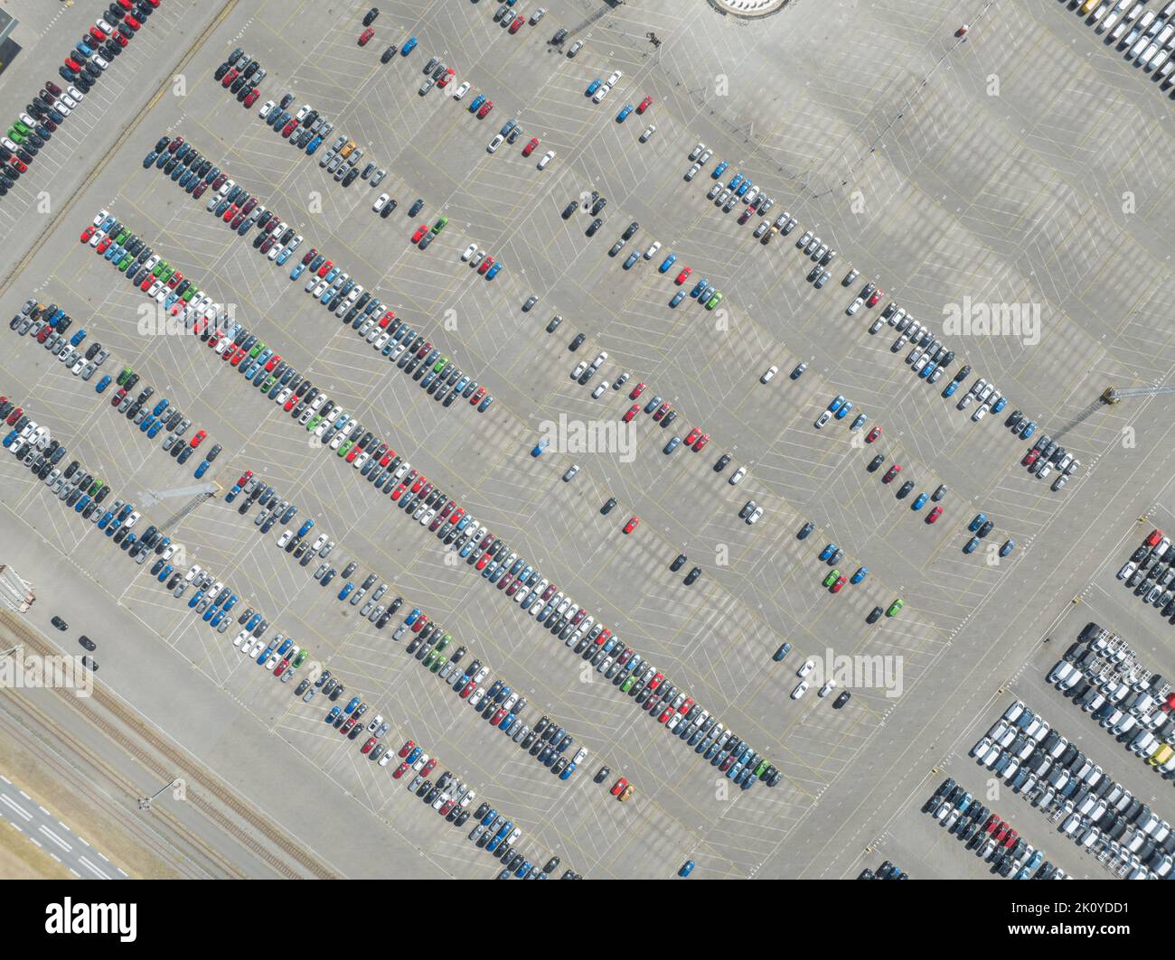 Vista dall'alto verso il basso del deposito di automobili di importazione ed esportazione nel porto. Industria automobilistica nuovi veicoli parcheggiati lotto pronto per la spedizione Foto Stock
