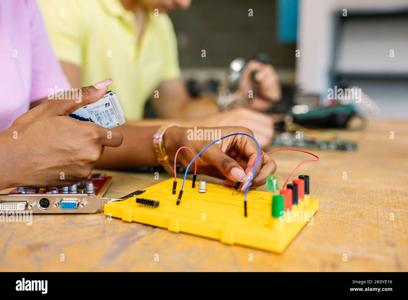 Primo piano le mani di una studentessa che crea circuiti elettronici e robotica in classe Foto Stock