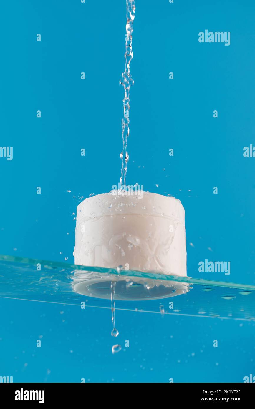 Vaso bianco con crema o maschera per viso e corpo con posto per il vostro logo su una mensola di vetro con spruzzi d'acqua Foto Stock