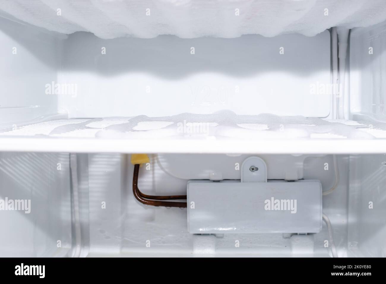 Scomparto congelatore con ghiaccio congelato ed evaporatore, messa a fuoco selettiva. Scongelare il frigorifero e il congelatore. Foto Stock