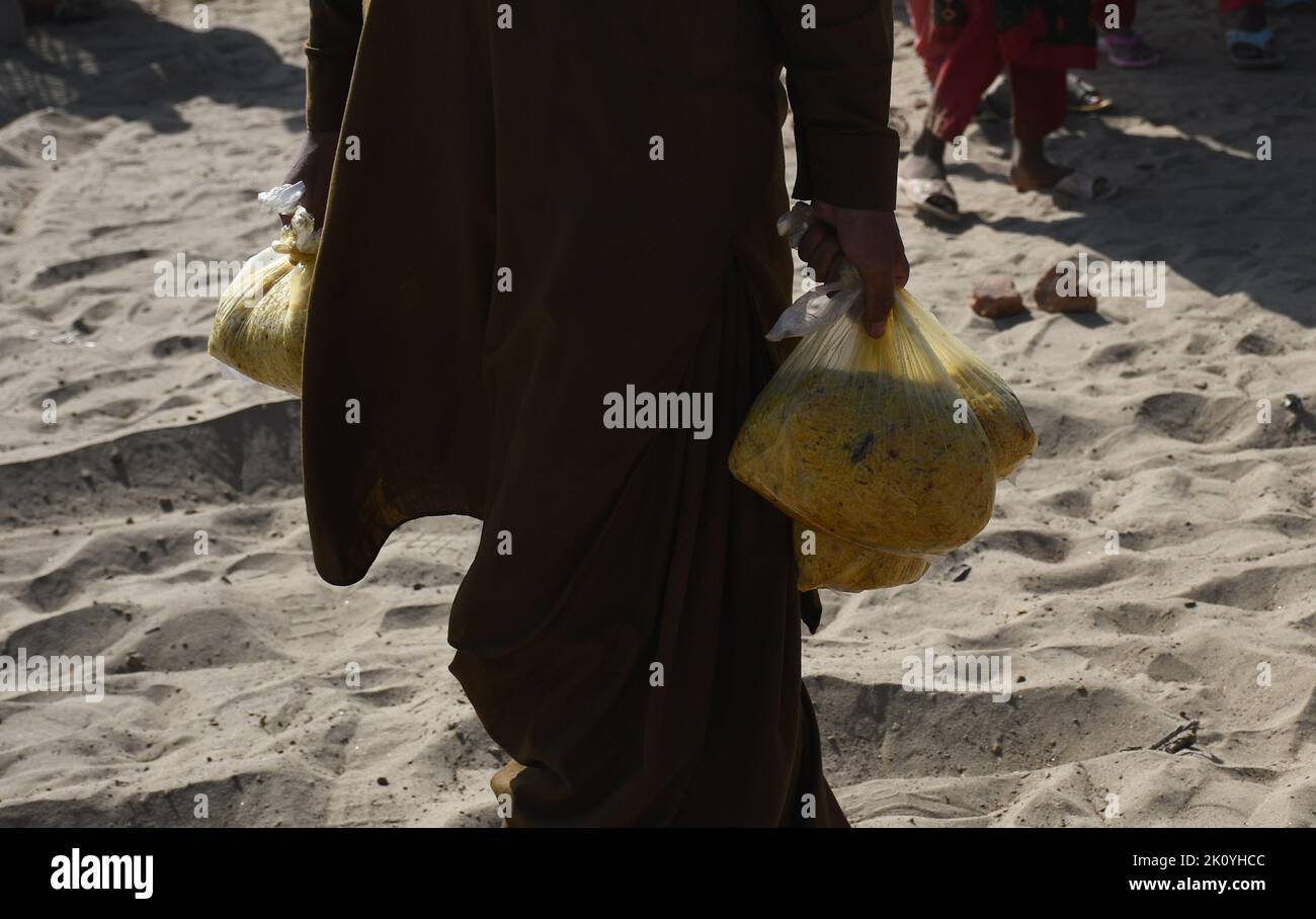 Le persone colpite dalle inondazioni ricevono aiuti a Sehwan, provincia di Sindh, Pakistan, 01 settembre 2022. Secondo la National Disaster Management Authority Foto Stock