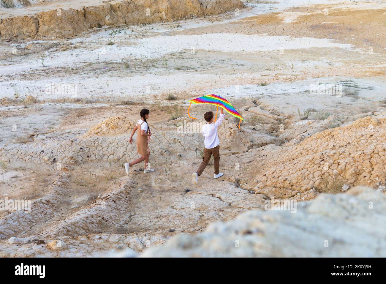 Bambini ragazzi e ragazze con un aquilone in mano salgono in alta montagna. Foto Stock