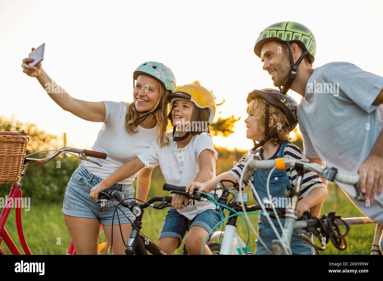 Felice famiglia in bicicletta insieme in campagna Foto Stock