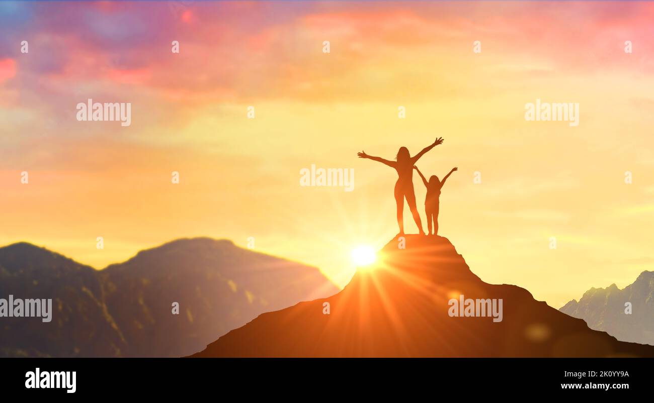 Operazione riuscita. Madre e figlia incontrano l'alba in cima alle montagne. Le donne di successo hanno raggiunto un nuovo picco di crescita personale e di sviluppo. Operazione riuscita Foto Stock