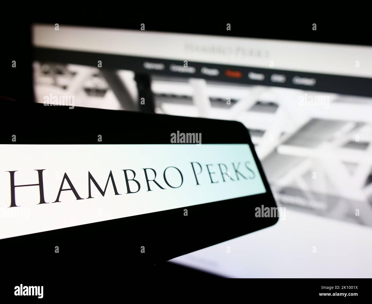 Smartphone con il logo della società di investimenti britannica Hambro Perks Limited sullo schermo di fronte al sito Web aziendale. Messa a fuoco a sinistra del display del telefono. Foto Stock