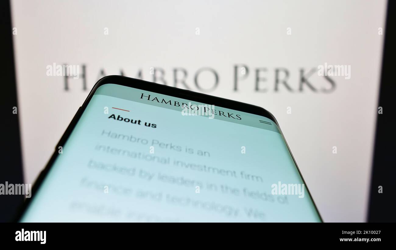 Telefono cellulare con sito web della società di investimento britannica Hambro Perks Limited sullo schermo di fronte al logo. Messa a fuoco in alto a sinistra del display del telefono. Foto Stock