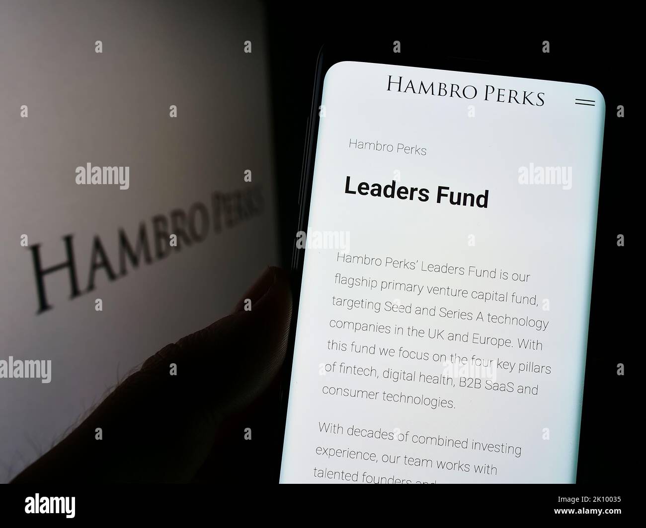 Persona che tiene il cellulare con il Web page della società britannica di investimento Hambro Perks Limited sullo schermo con il logo. Messa a fuoco al centro del display del telefono. Foto Stock