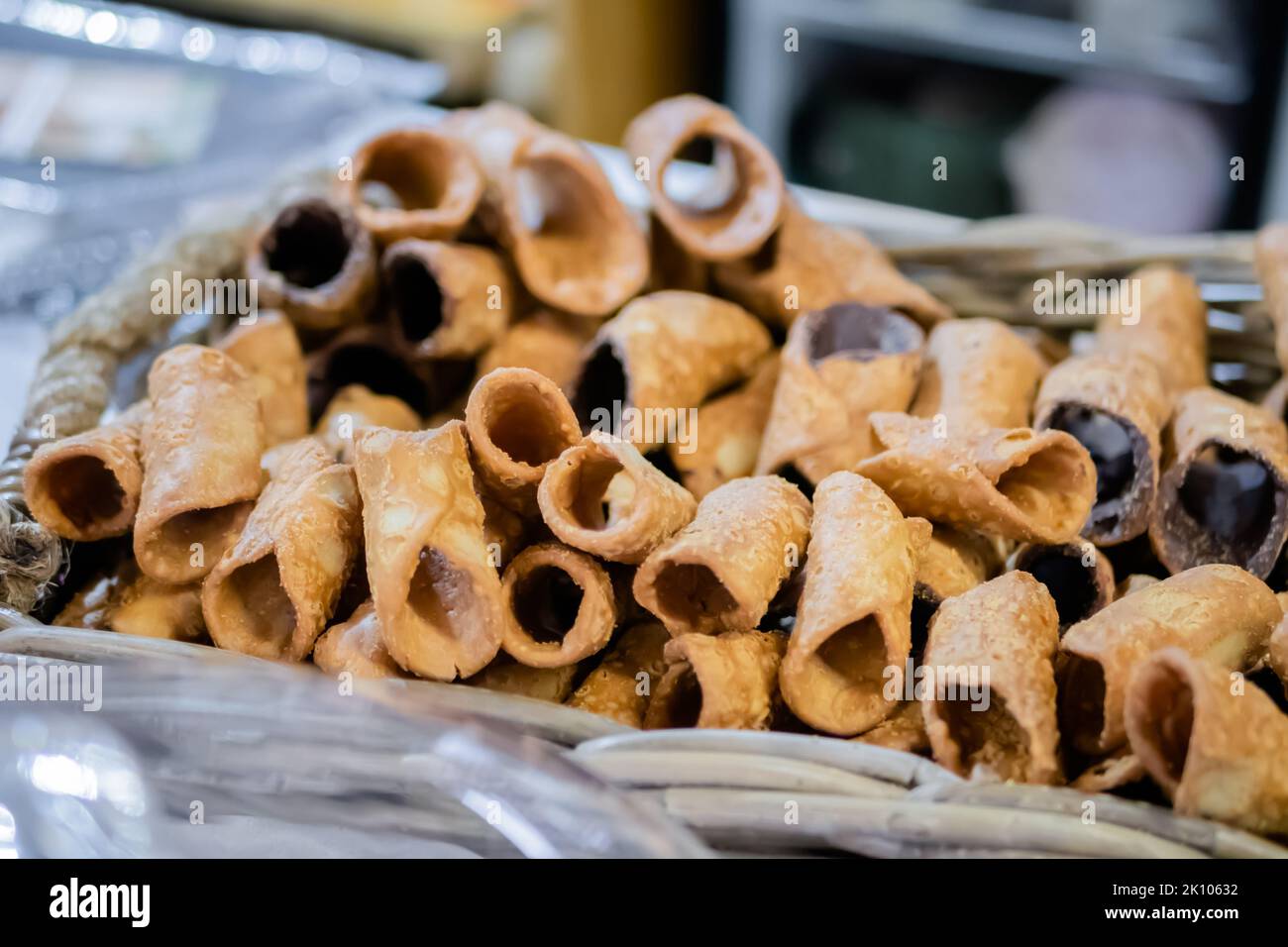 Dolci cannoli fritti vuoti nel cestino al banco del mercato alimentare Foto Stock