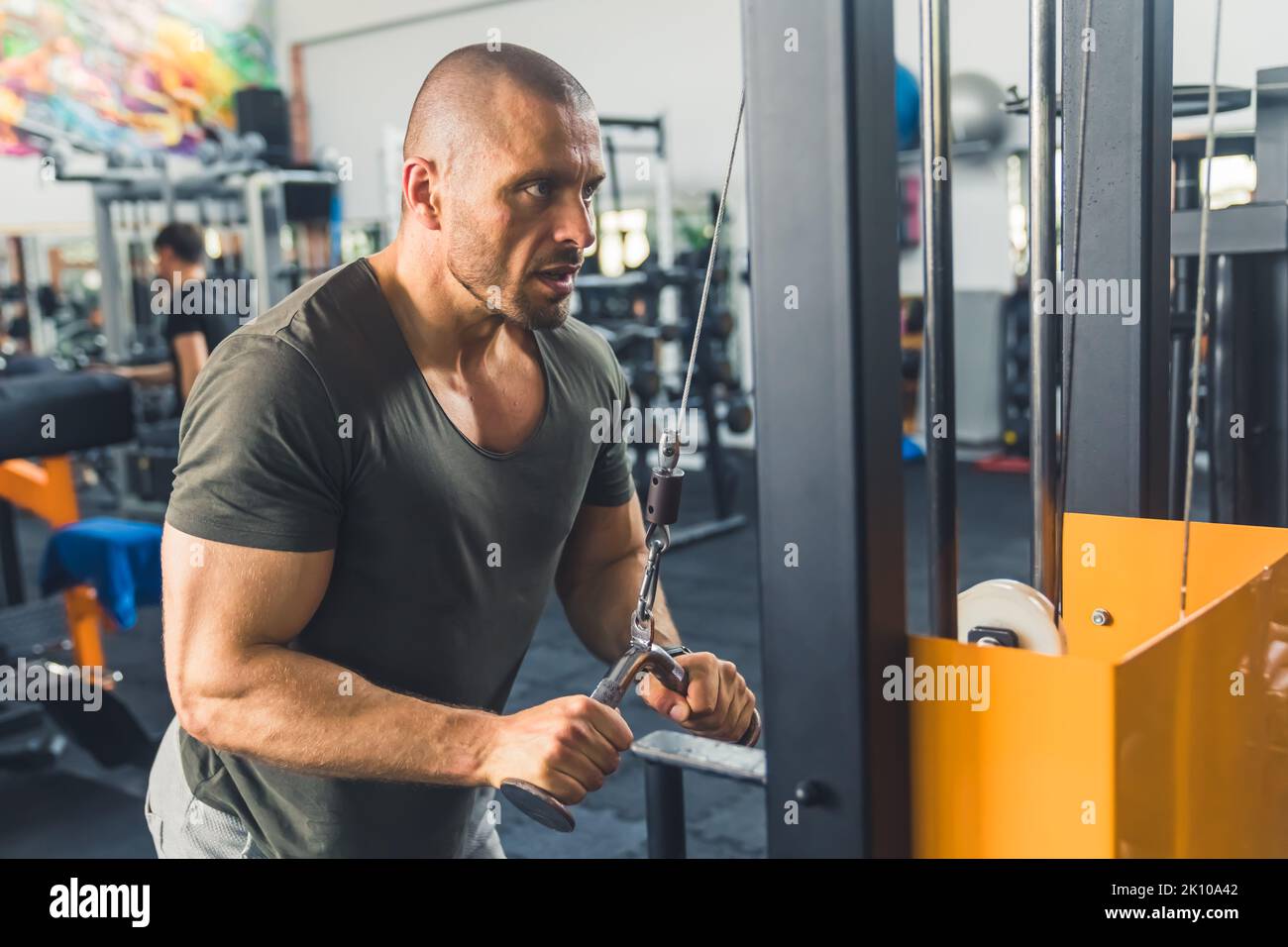 fitness giovane uomo utilizzando una macchina a remi in palestra, a medio tiro sano stile di vita concetto. Foto di alta qualità Foto Stock